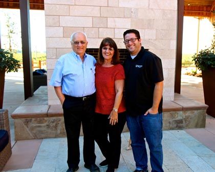 Bob, Dorothy and Dan Panella in front of outdoor fireplace