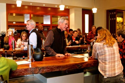 Wine and chocolate lovers being served by Brad and Randy Lange in LangeTwins Winery’s Press Room (tasting bar in barrel room beneath massive wine presses)…