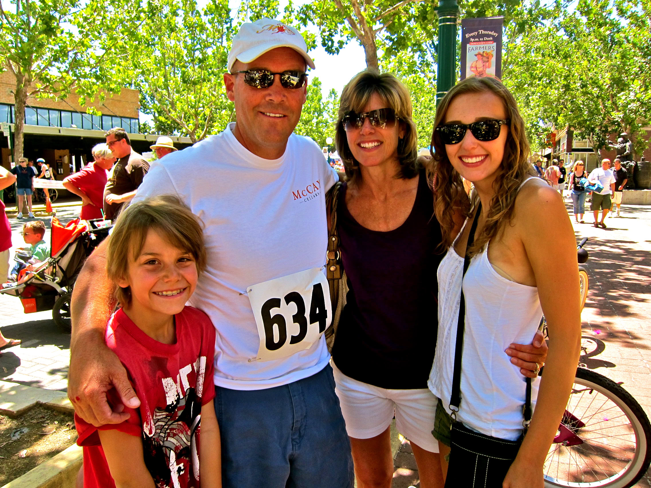 Family at Lodi Wine Festival with trees and crowd in background.