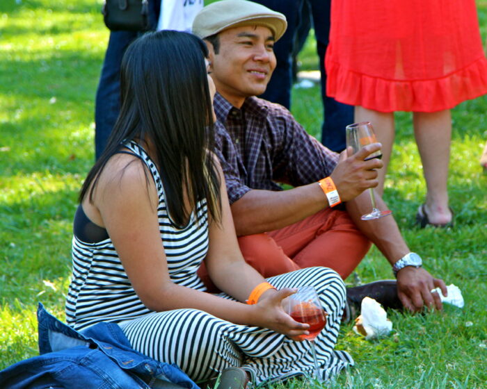 People enjoying wine tasting outdoors at a Lodi Winegrape Commission event.