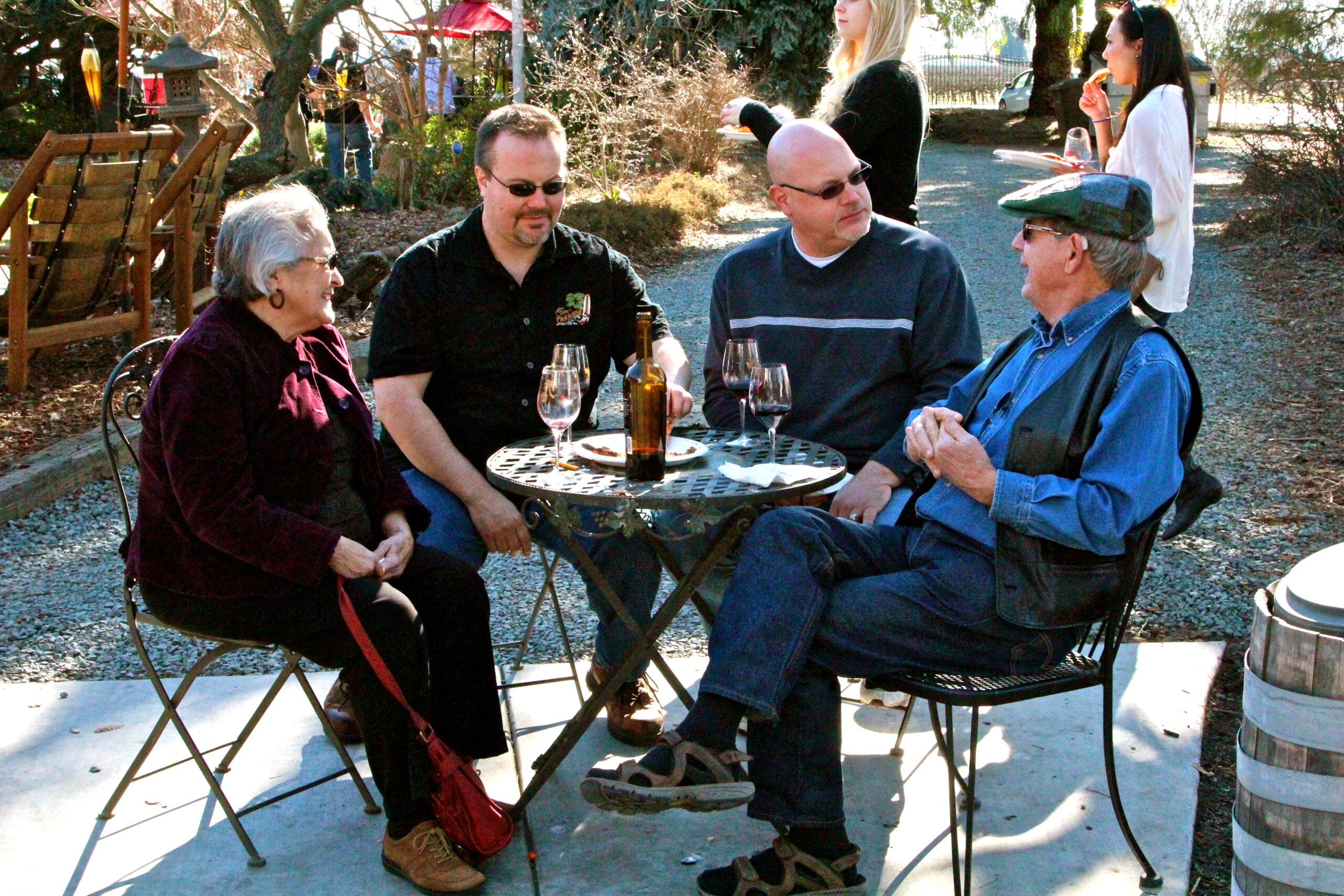 Group of four people enjoying wine outdoors at a Lodi vineyard event.