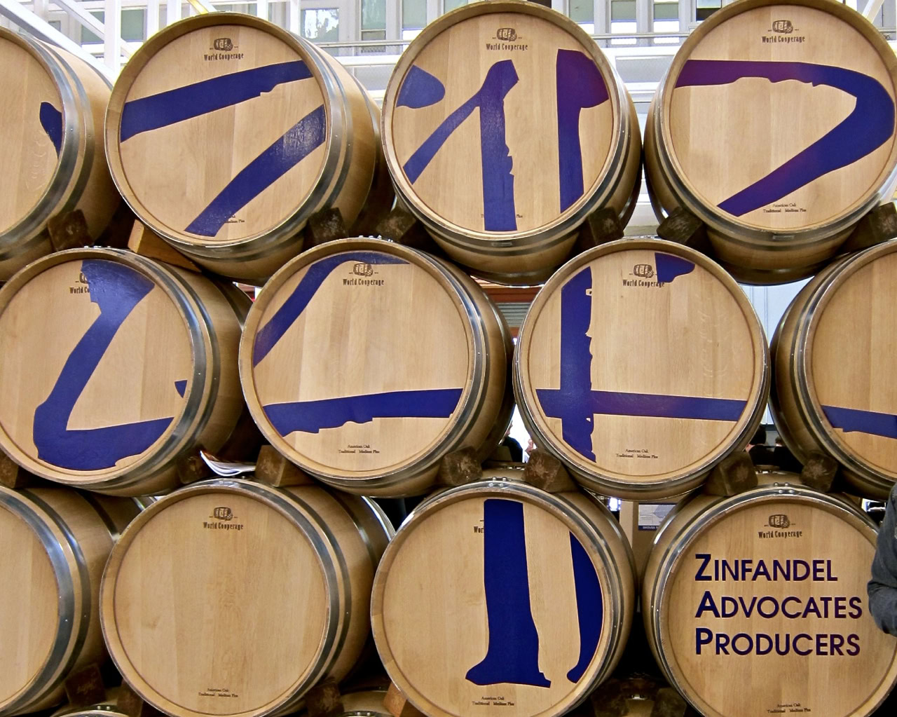 Wine barrels with blue painted numbers and Zinfandel Advocates Producers logo at Lodi Winegrape Commission.