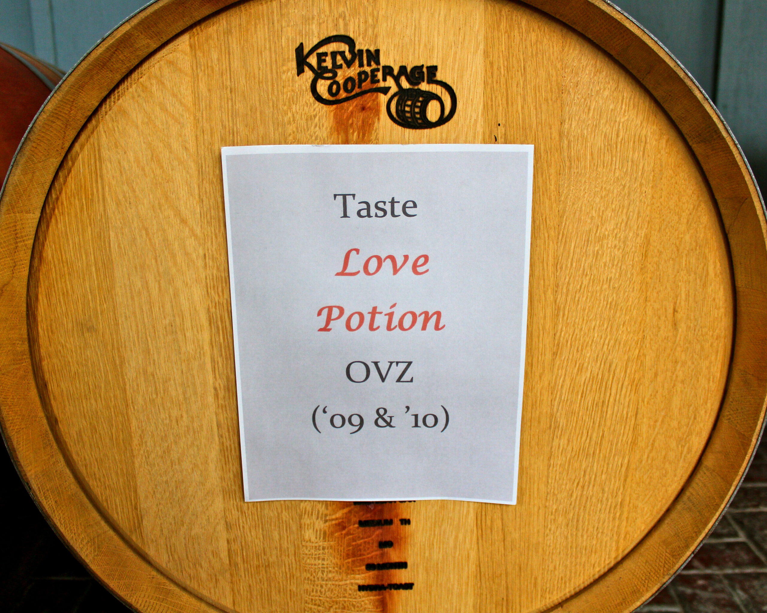 Barrel label with the words Taste Love Potion OVZ 09 & 10, on a wooden wine barrel at Lodi Winegrape Commission.