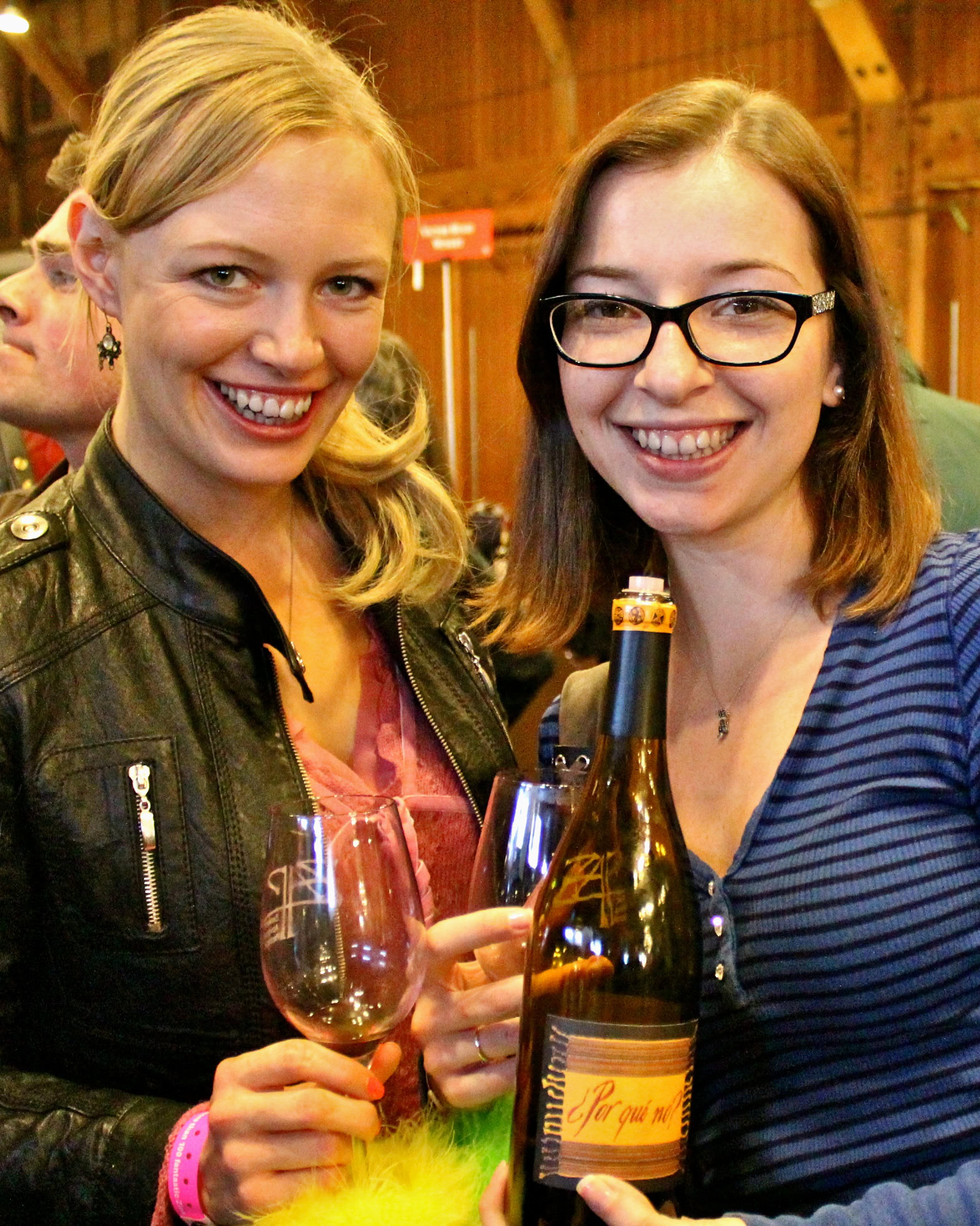 Two women enjoying wine at a Lodi Winegrape Commission event, holding wine glasses and a bottle, smiling at the camera.