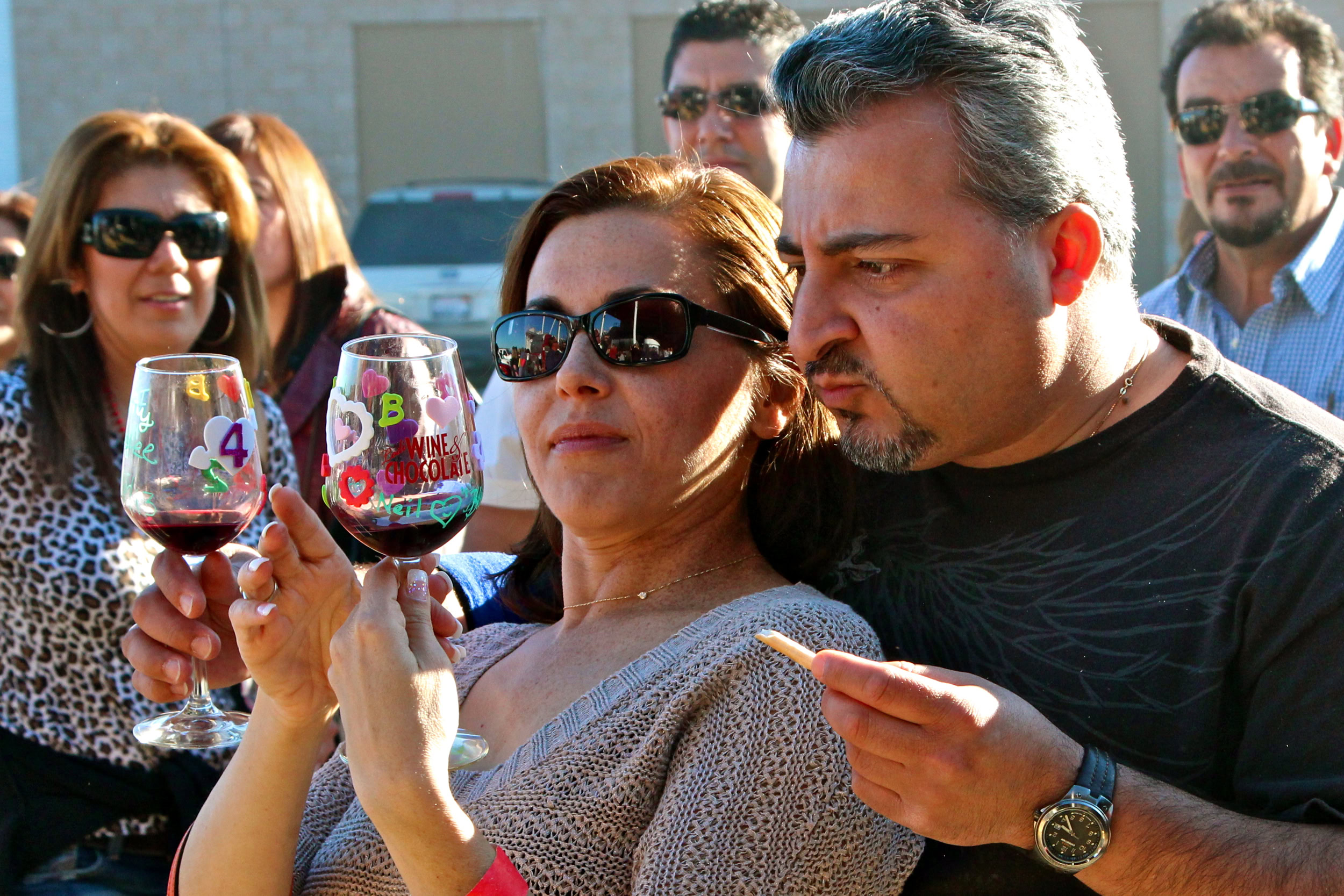 People tasting wine at a Lodi Winegrape Commission event, enjoying wine samples outdoors.