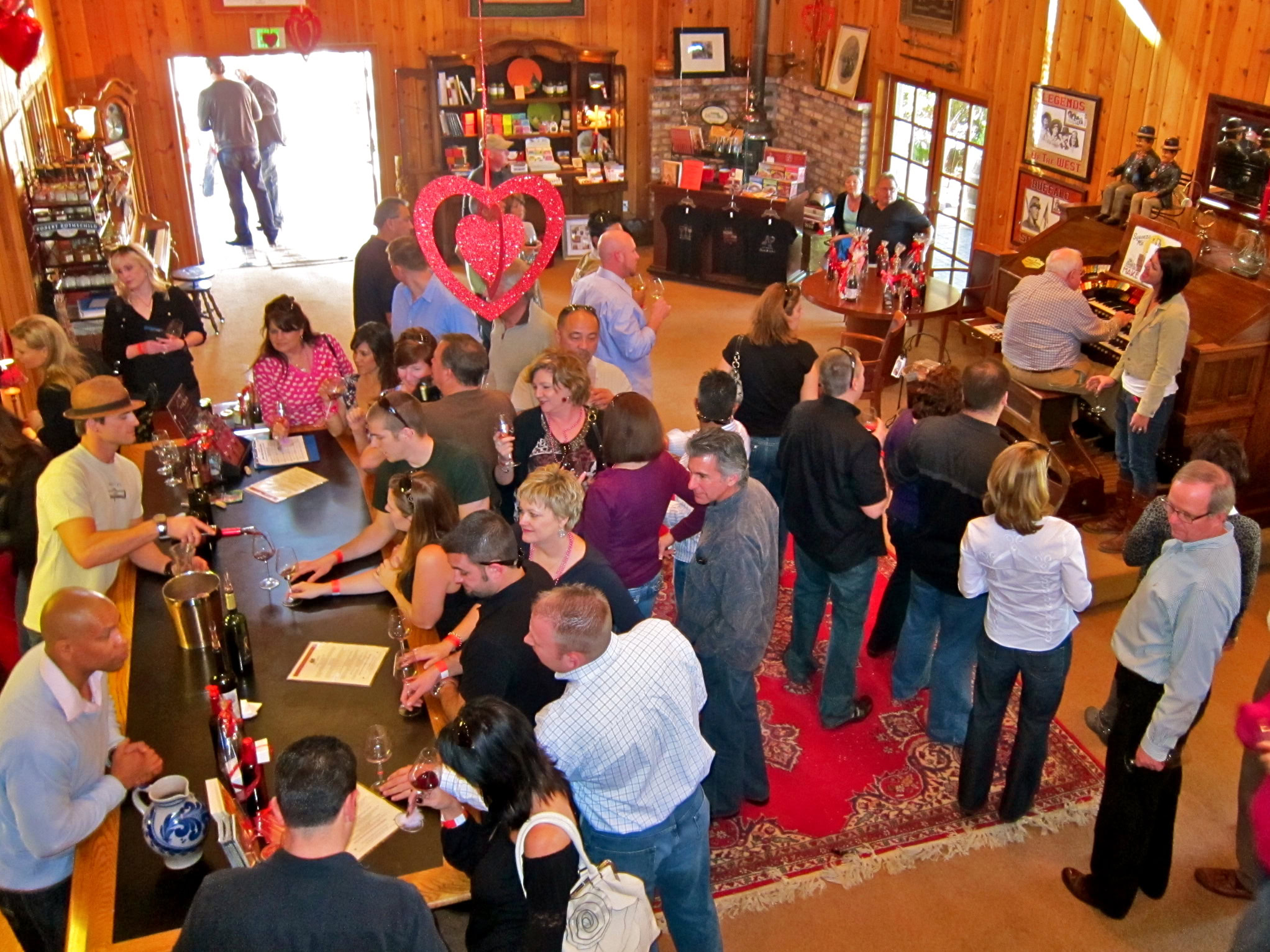 Crowd enjoying wine tasting at a Lodi Winegrape Commission event in a rustic venue.