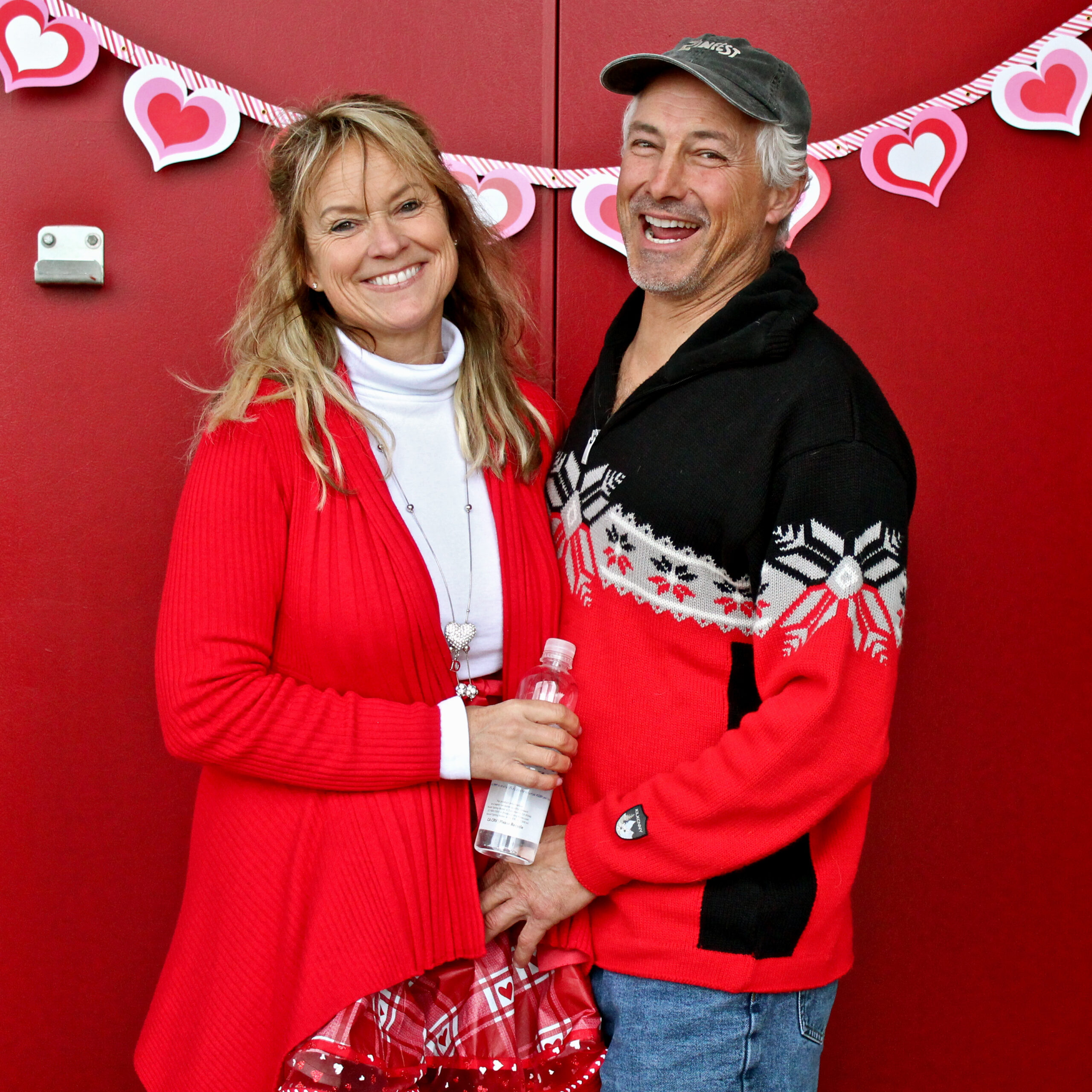 Smiling couple at Lodi Winegrape Commission event with Valentine's Day decorations.