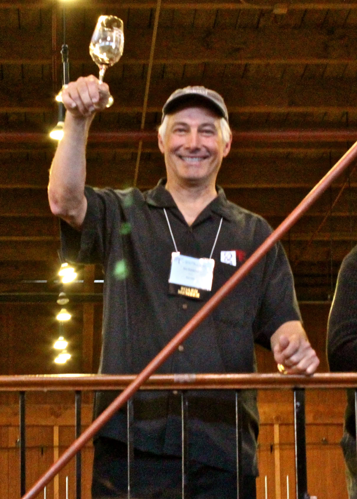 Smiling man holding a wine glass at a Lodi Winegrape Commission event.