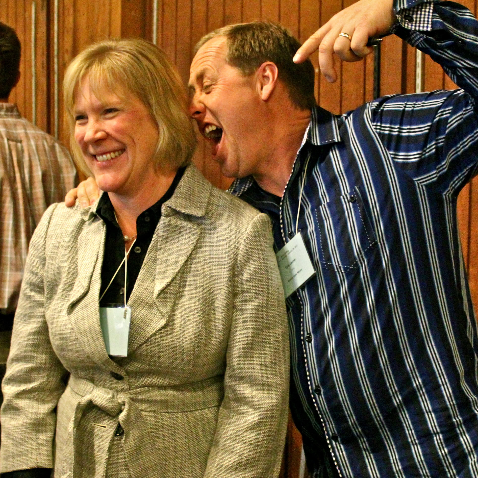 Two people laughing and enjoying a wine-related event at the Lodi Winegrape Commission.