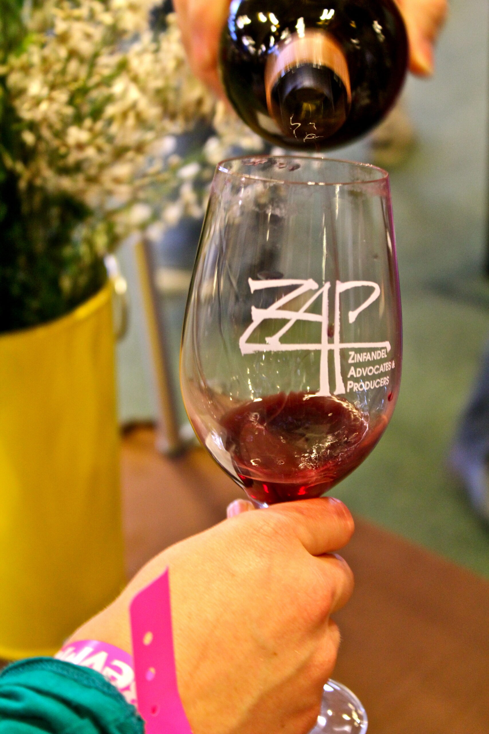 Pouring red wine into a glass at a wine tasting event, showcasing Lodi wine region.