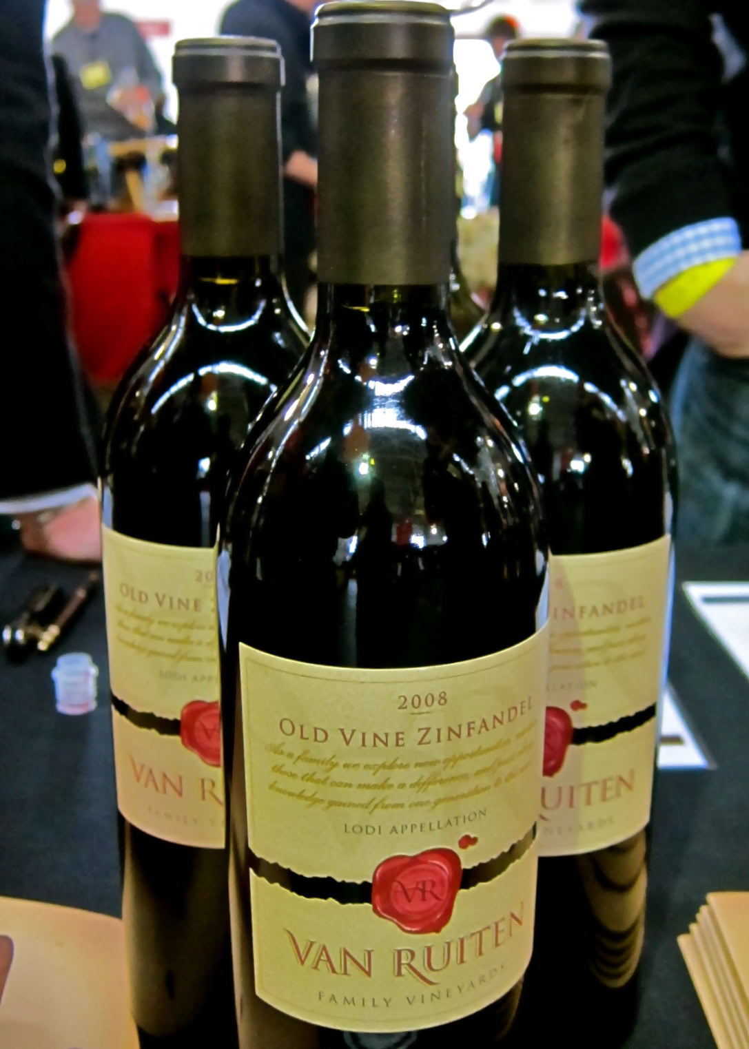 Three bottles of Van Ruiten Old Vine Zinfandel wine from Lodi, California, at a wine tasting event.