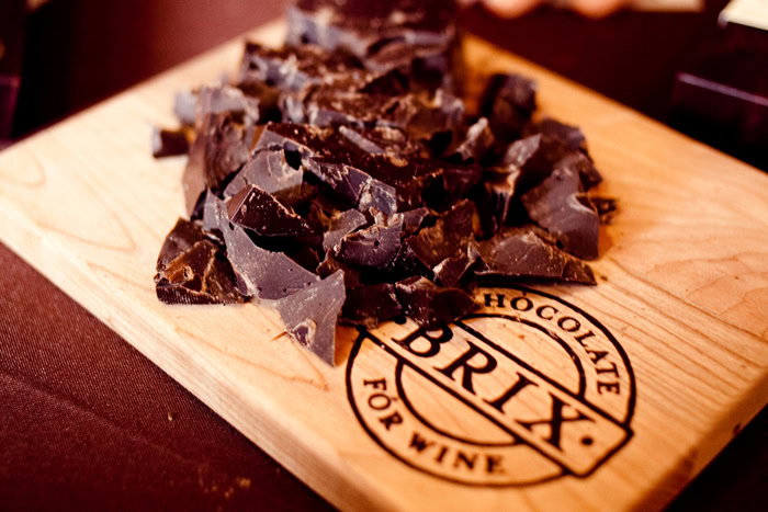 Dark chocolate chunks on a wooden board with Lodi Winegrape Commission branding for wine and chocolate pairing.