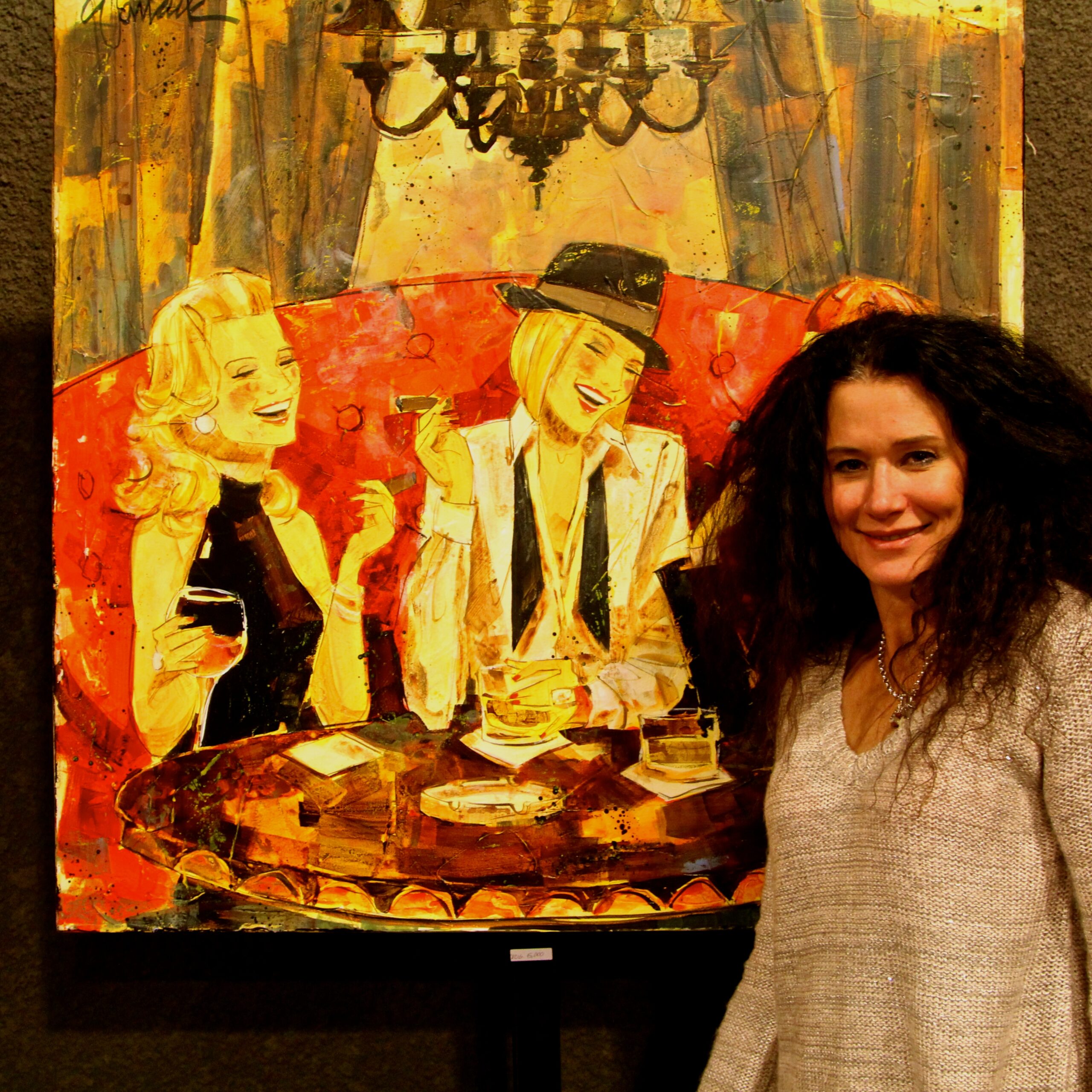 Woman standing next to colorful painting of women enjoying wine at a table.