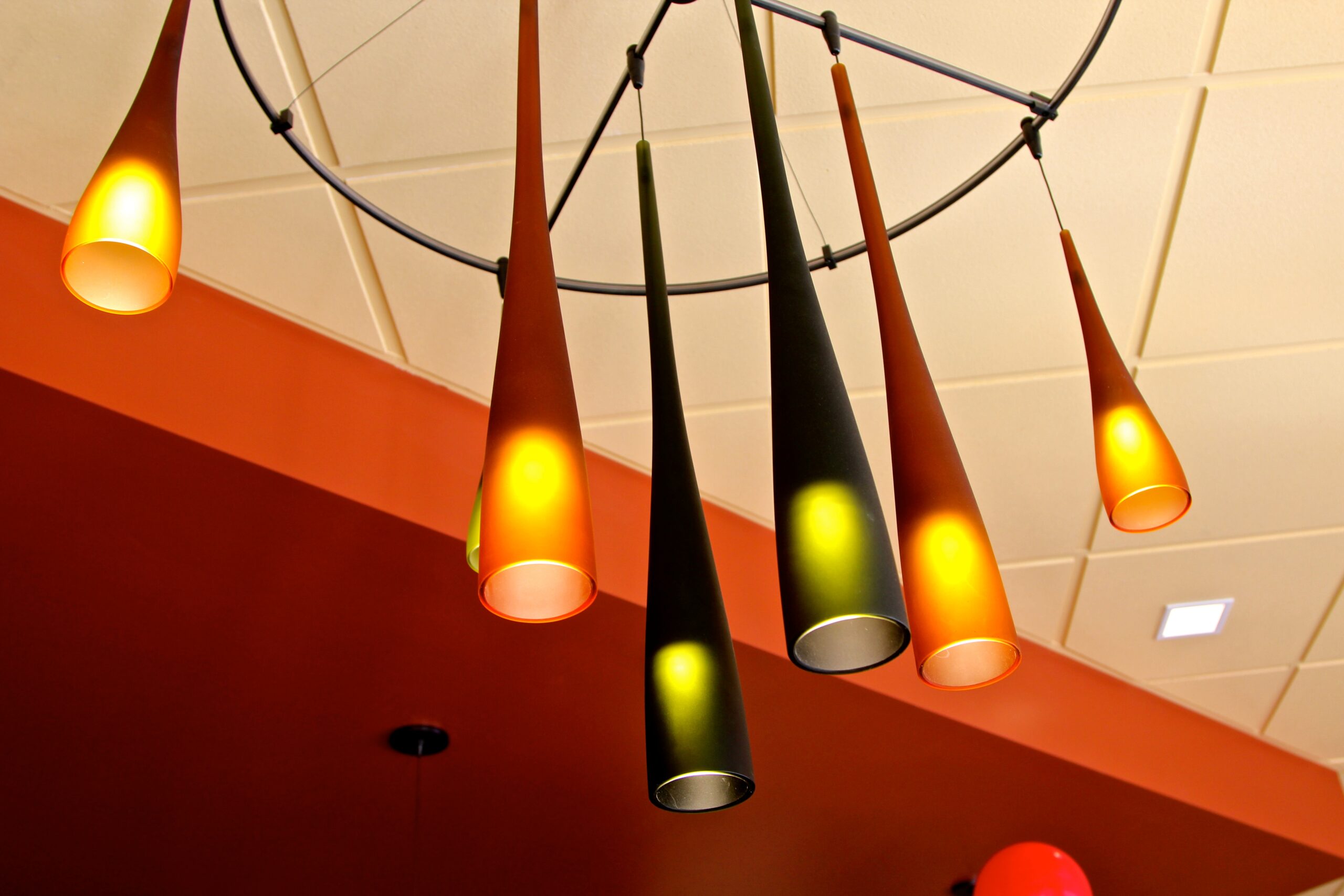 Colorful modern pendant lights hanging from the ceiling in a wine tasting room.