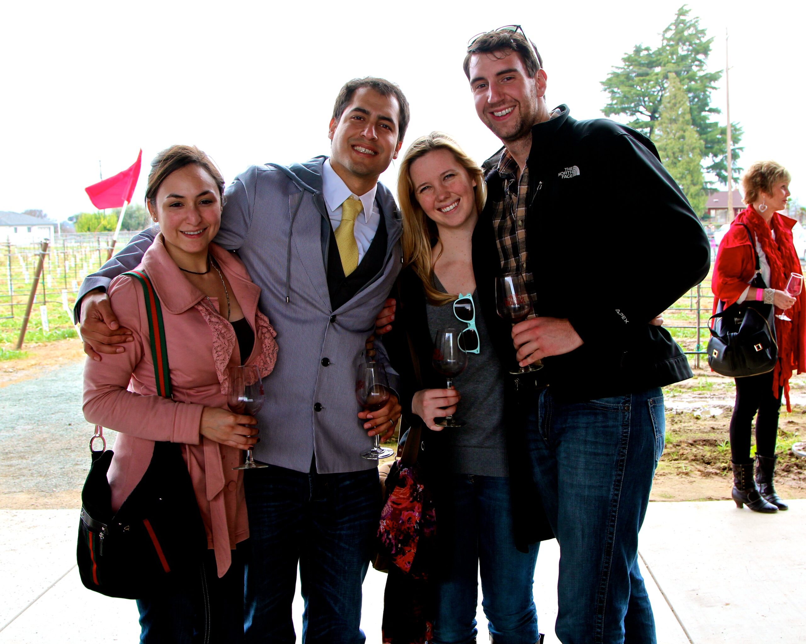 Group of smiling people enjoying wine tasting at Lodi Winegrape Commission event.