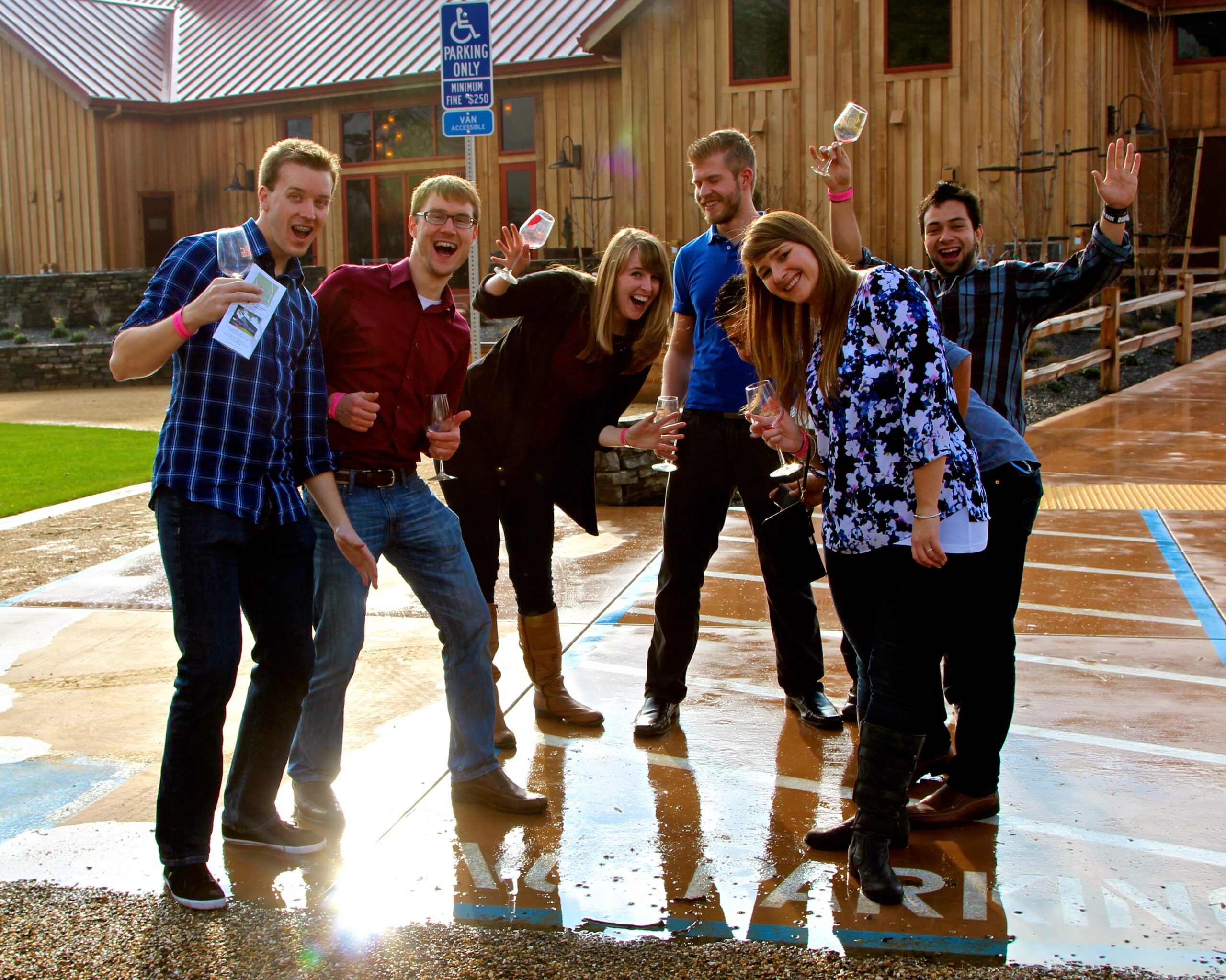 Group of people celebrating outdoors at Lodi Winegrape Commission event, holding glasses of wine and smiling.