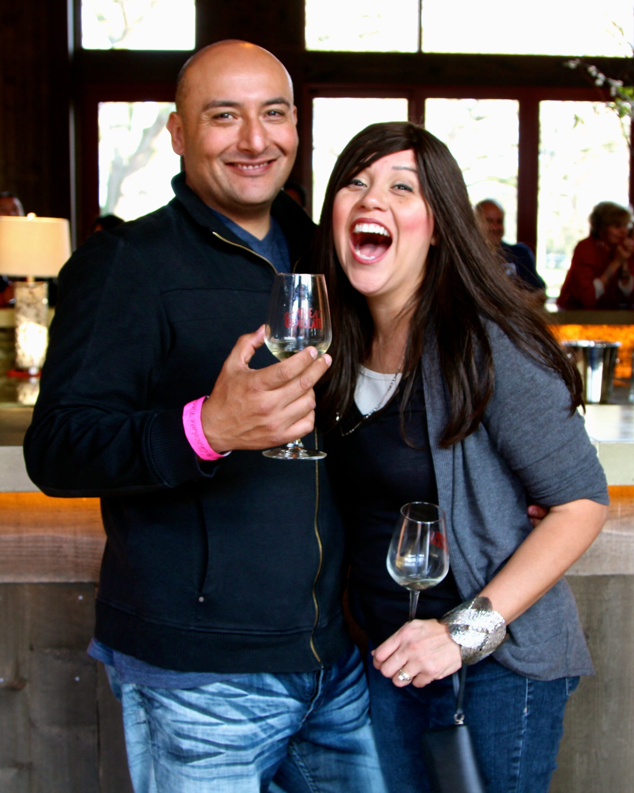 Happy couple enjoying wine at Lodi Winegrape Commission event in a cozy indoor setting.