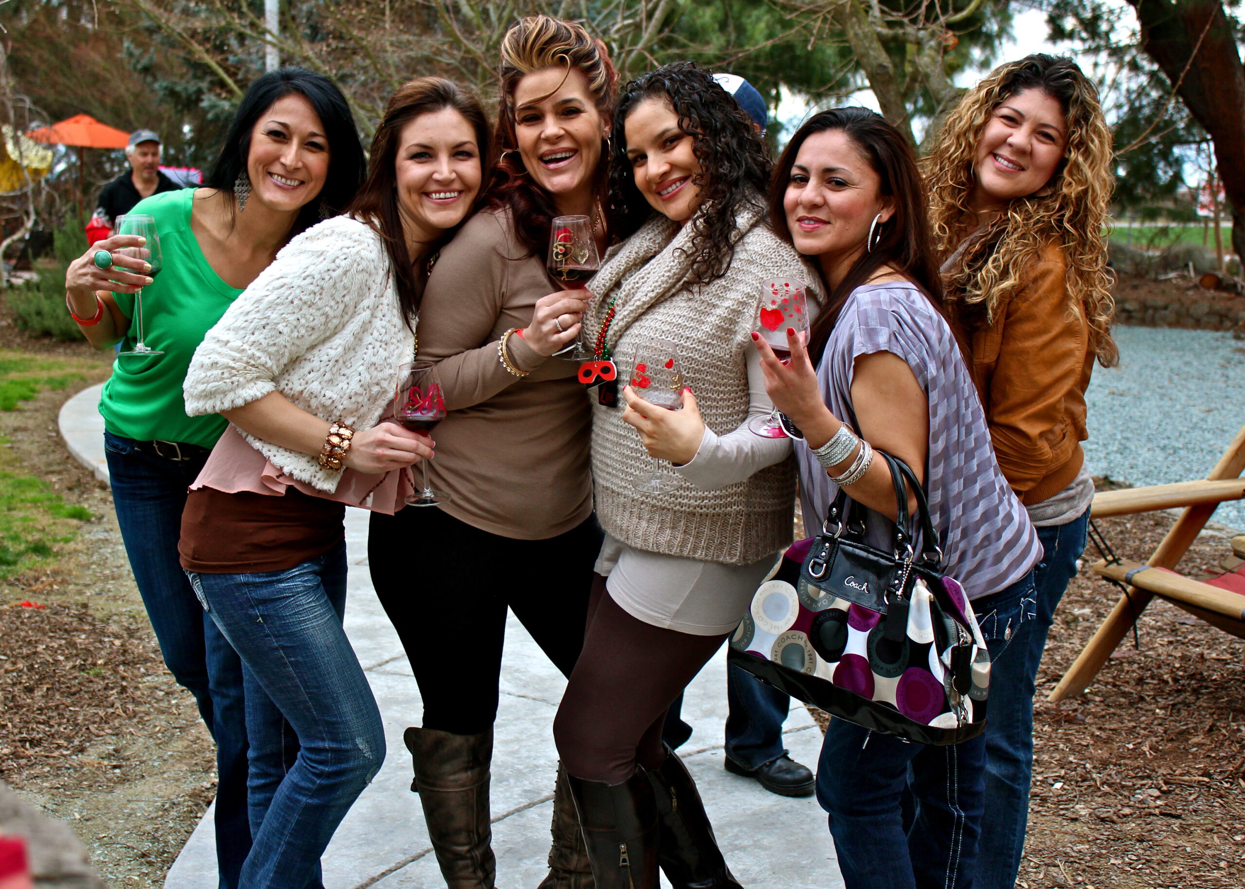 Group of women smiling and holding wine glasses at a wine tasting event in Lodi, California.