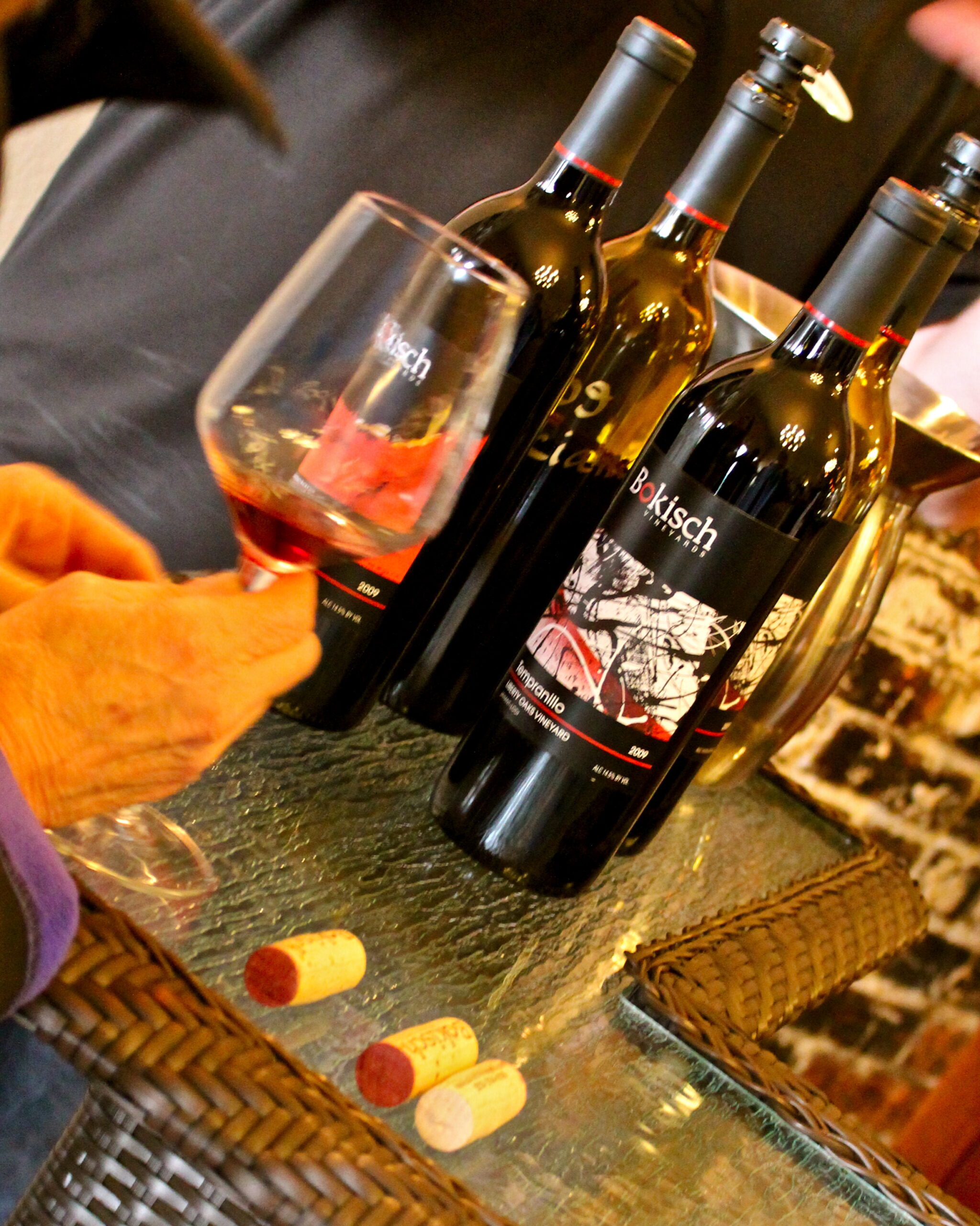 Wine bottles and glass at Lodi Winegrape Commission tasting event, showcasing local wines from Lodi, California.