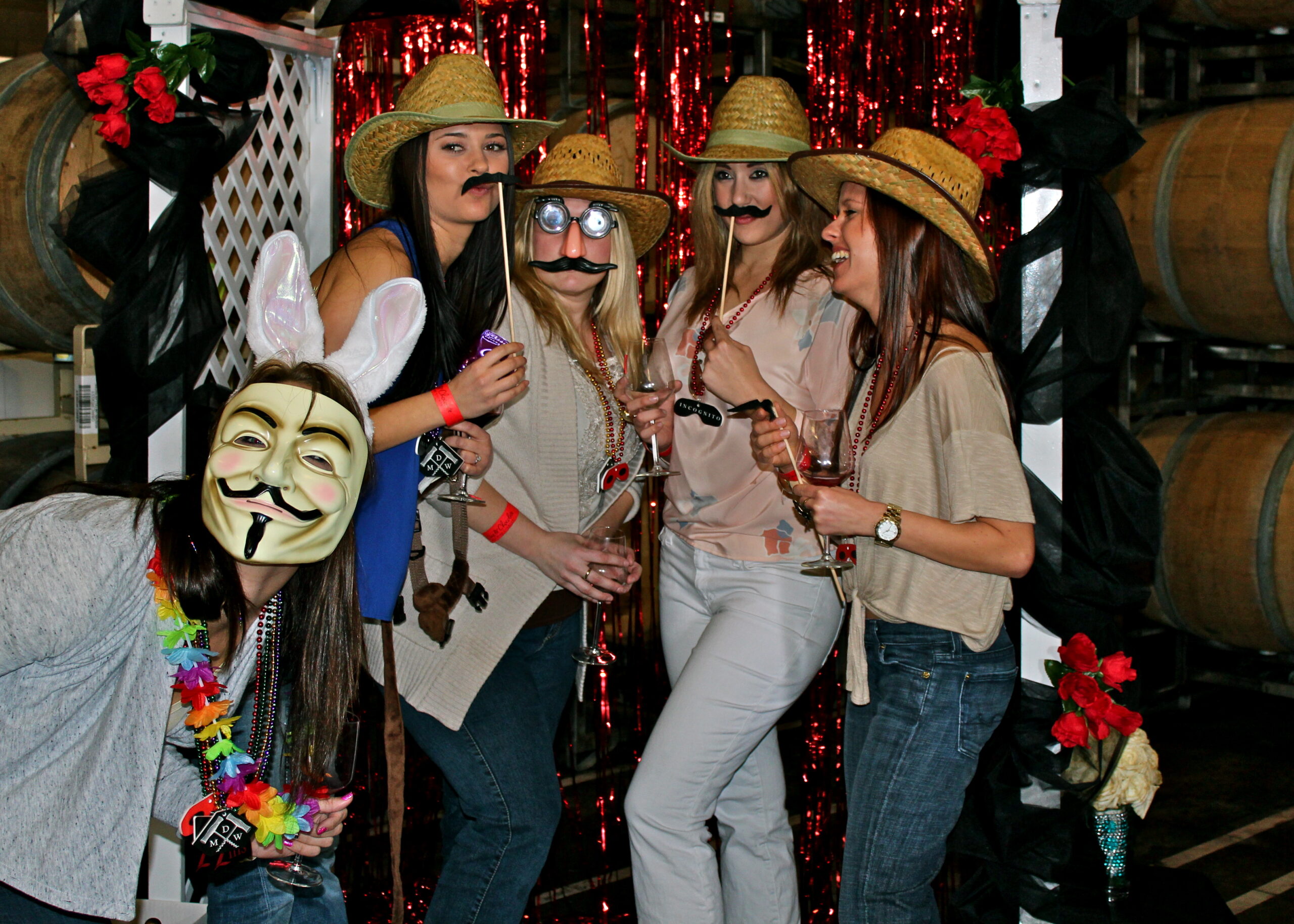 Group of women wearing straw hats and fake mustaches at Lodi Winegrape Commission event.