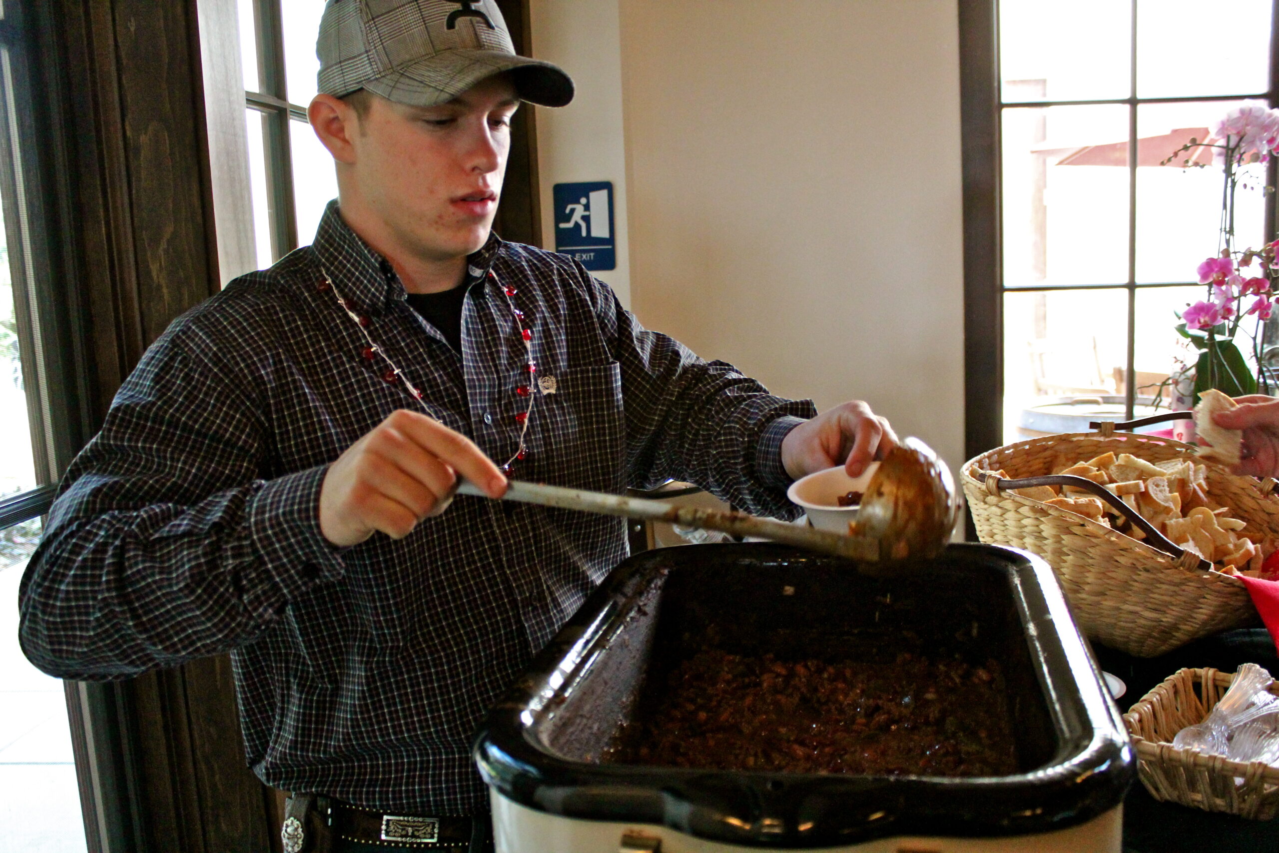 Young man serving food at Lodi Winegrape Commission event, showcasing local wine and food pairing.