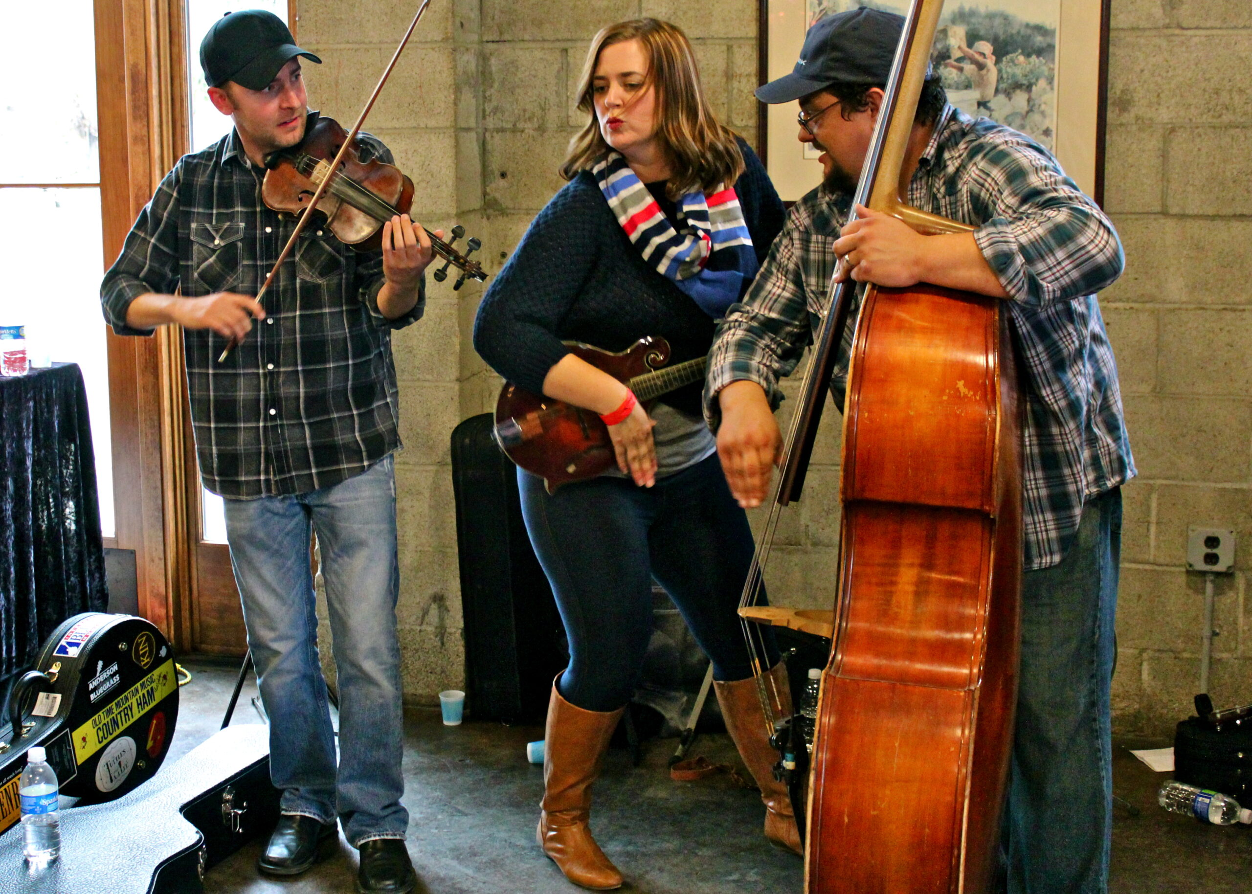 Musicians playing string instruments at a Lodi Winegrape Commission event in a rustic setting.