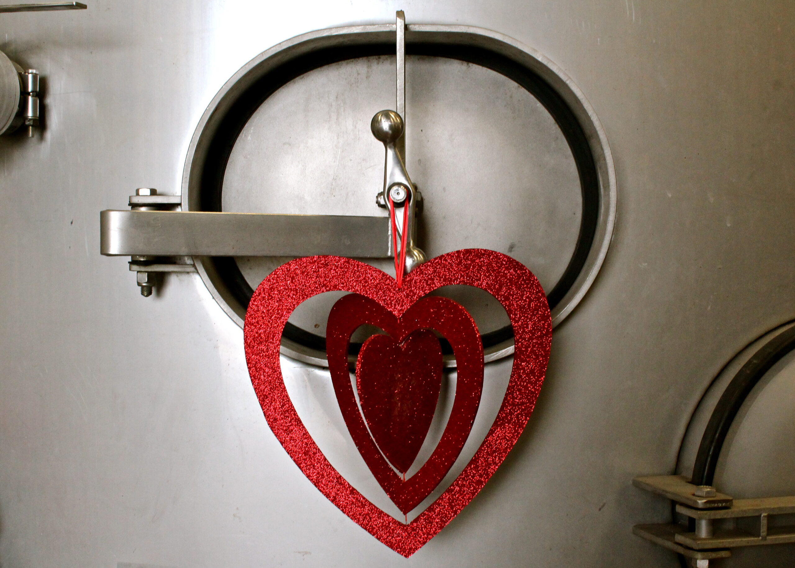 Heart-shaped Valentine's Day decoration hanging on a wine fermentation tank at Lodi Winegrape Commission.