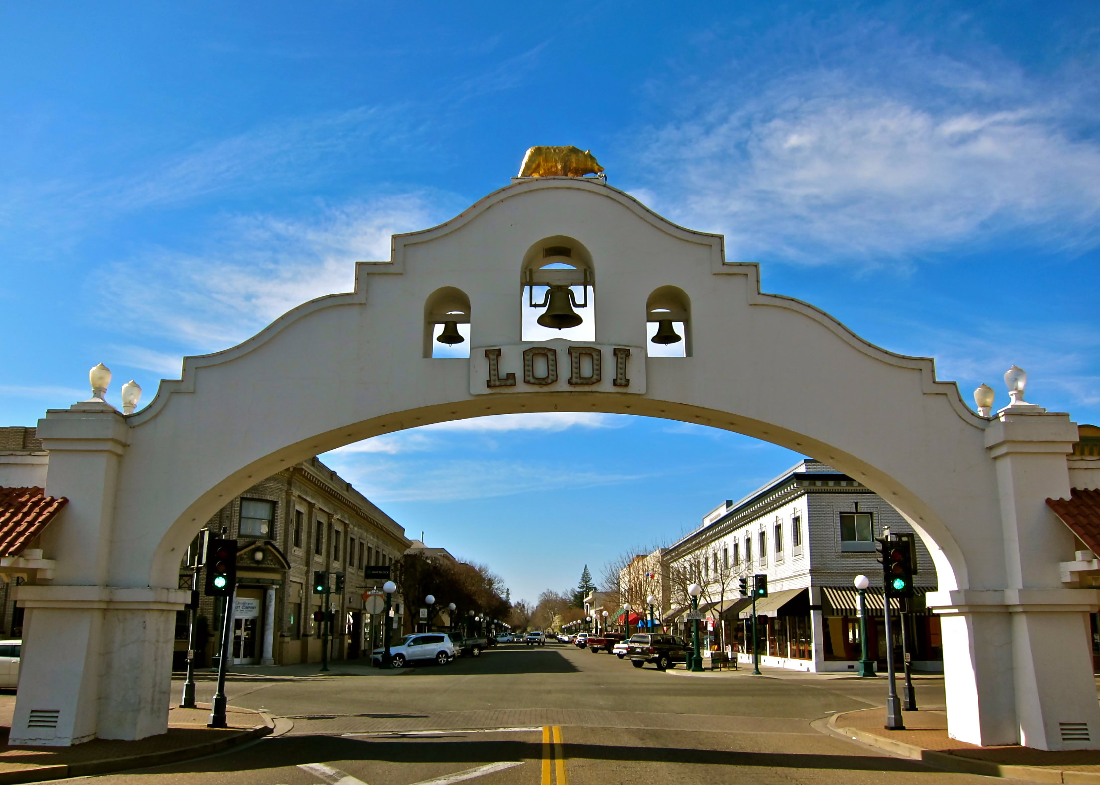 Iconic Lodi gateway arch with bell and city street view, representing Lodi Winegrape Commission's wine industry.