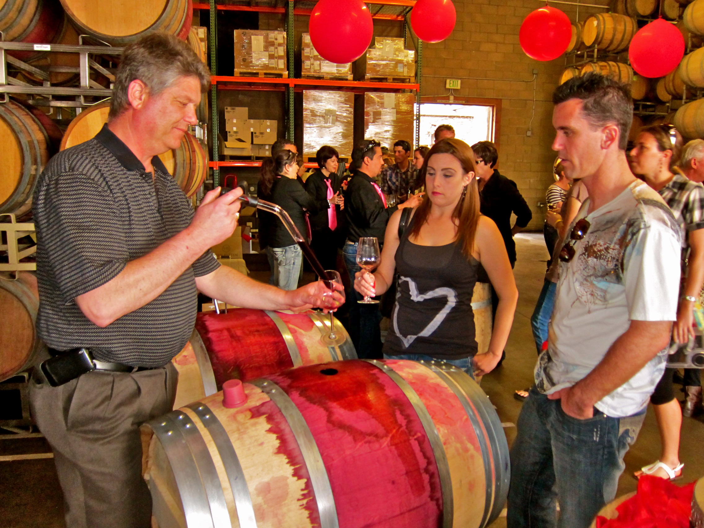 People tasting wine at a Lodi wine tasting event in a winery setting.