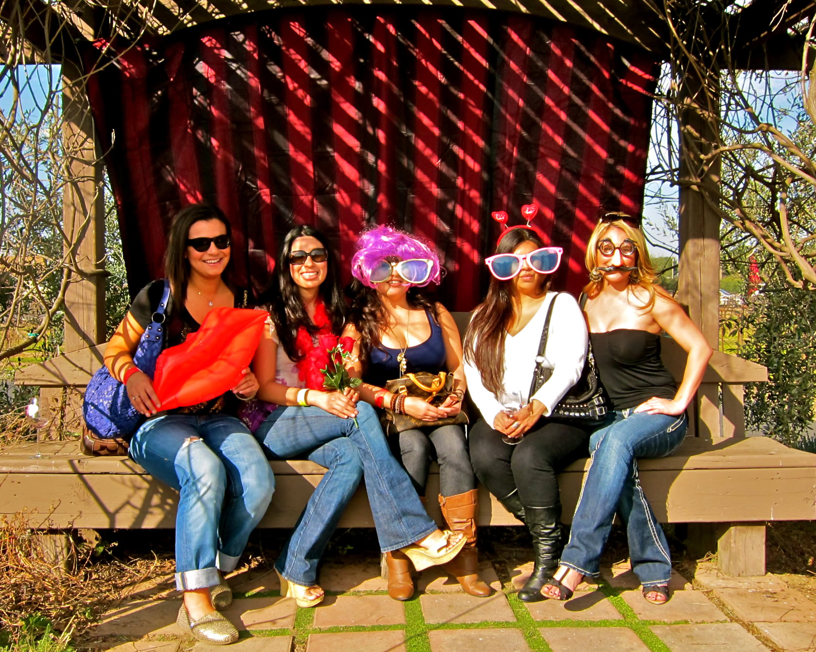 Group of women enjoying a fun outdoor event with costumes and sunglasses in Lodi, California.