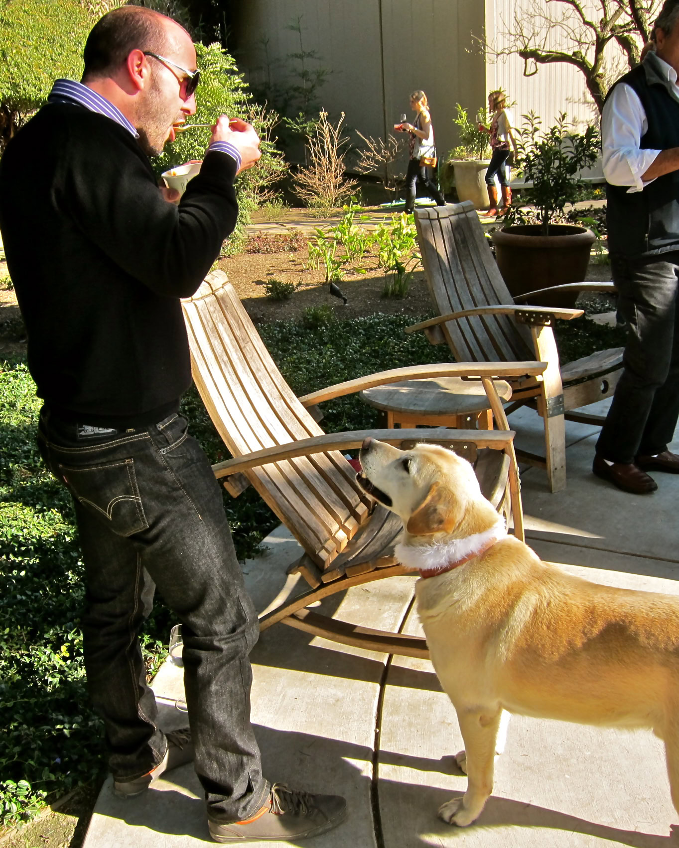 Man with dog at Lodi Winegrape Commission outdoor event, engaging with a camera.