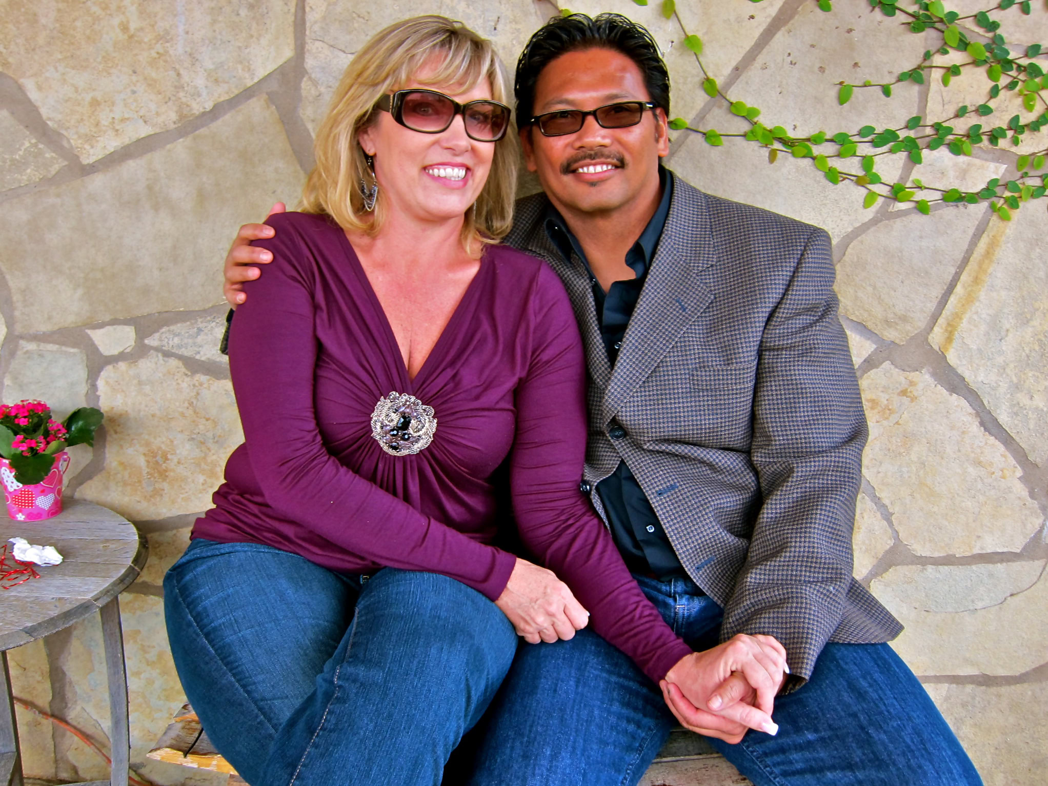 Smiling woman and man sitting together outdoors, celebrating Lodi wine culture.