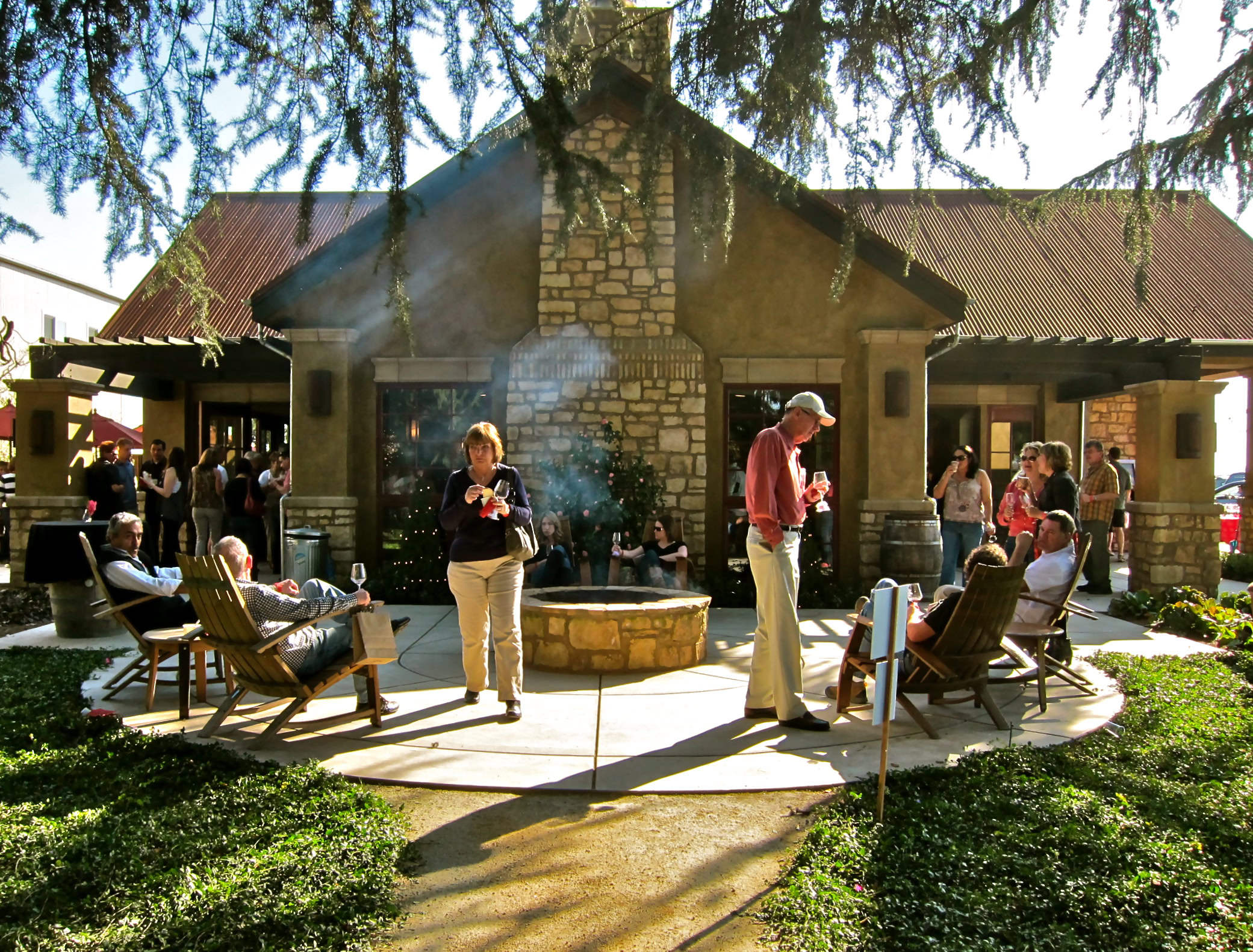 People enjoying a social gathering around a fire pit at a winery in Lodi, California.