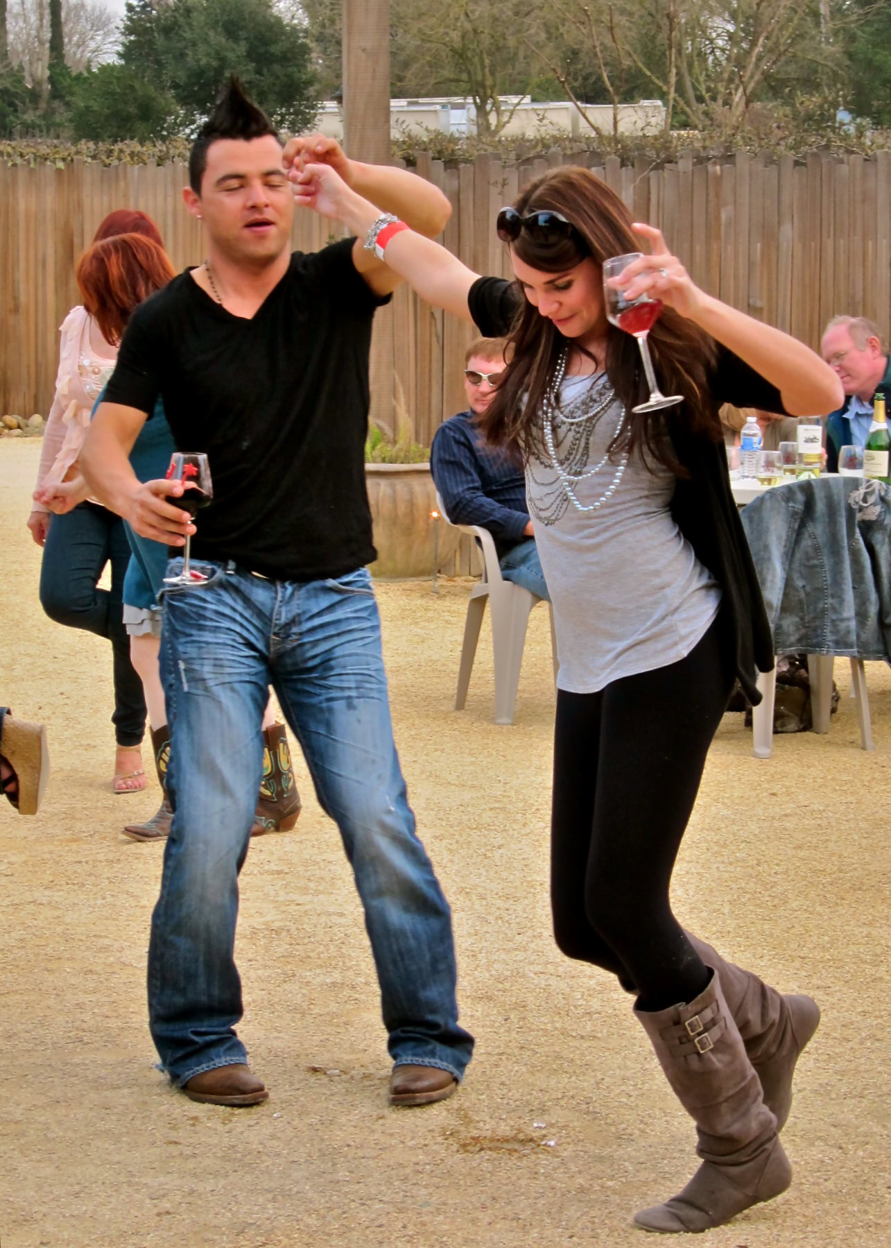 People enjoying wine and dancing outdoors at a Lodi Winegrape Commission event.