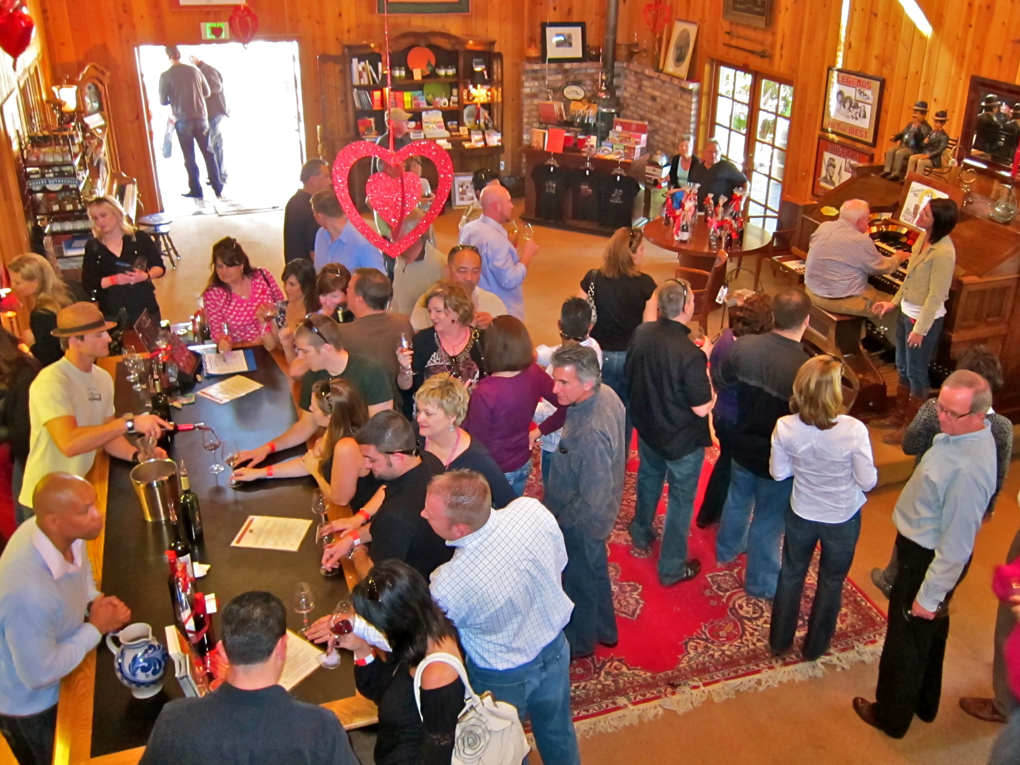 Crowd of people at Lodi Winegrape Commission event in a rustic winery setting.