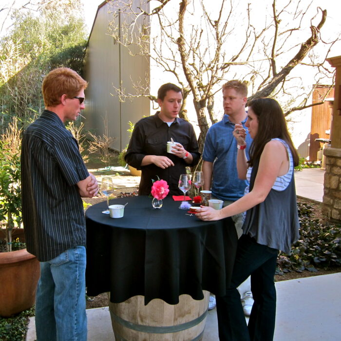 Group of people enjoying wine tasting outdoors at a Lodi Winegrape Commission event.