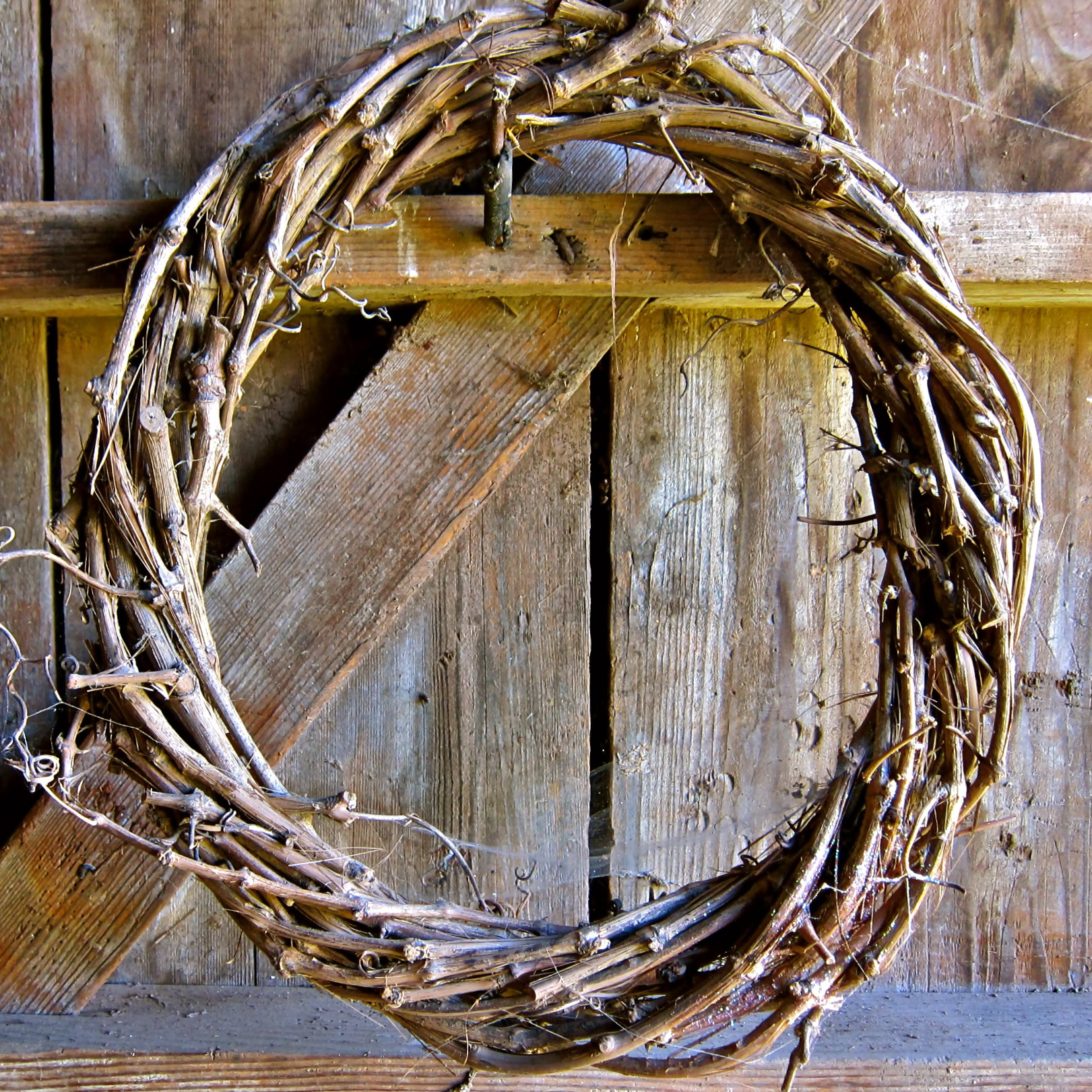 Rustic grapevine wreath hanging on wooden barn door, representing Lodi wine region.