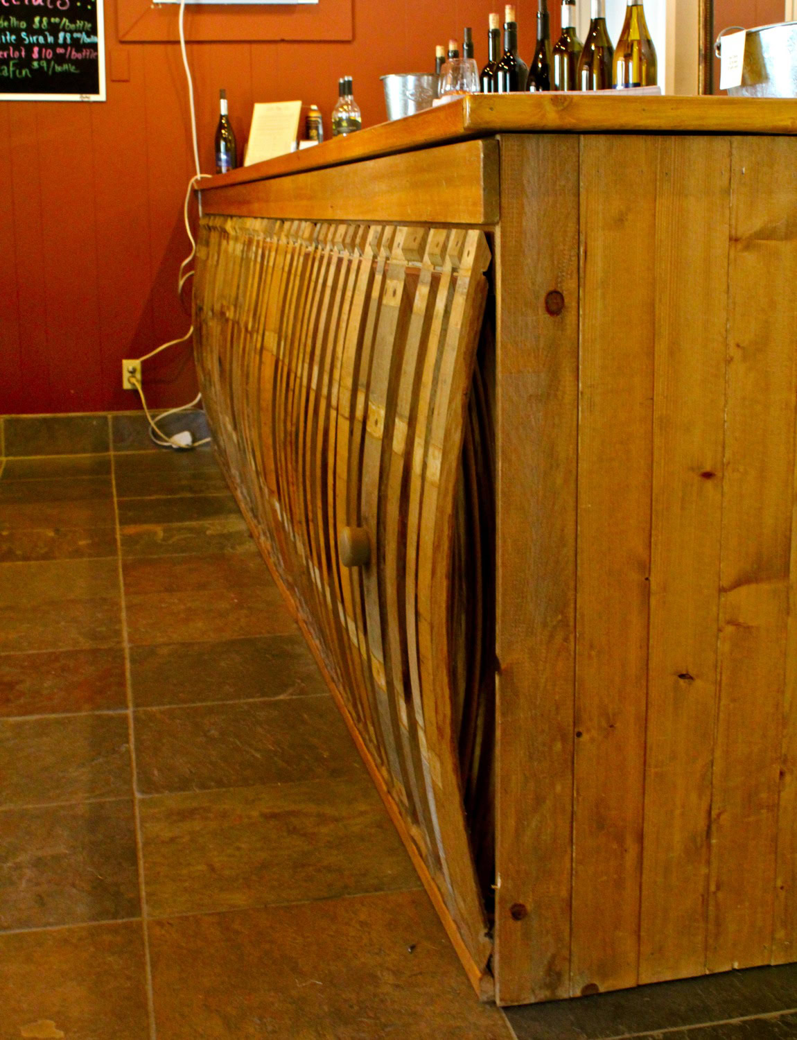 Wooden bar counter with wine bottles and glasses at Lodi Winegrape Commission.