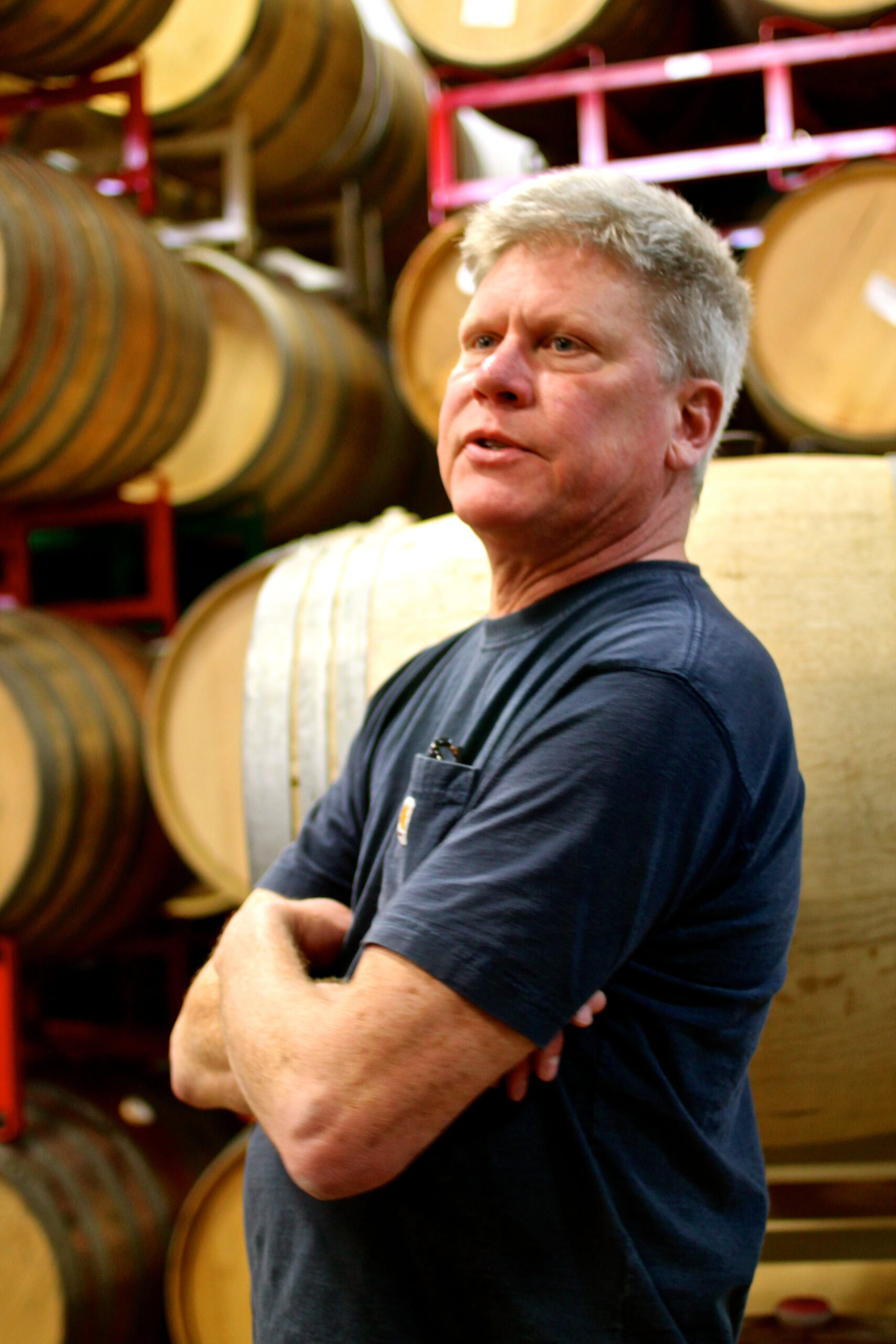 Man inspecting wine barrels at Lodi Winegrape Commission facility in California.