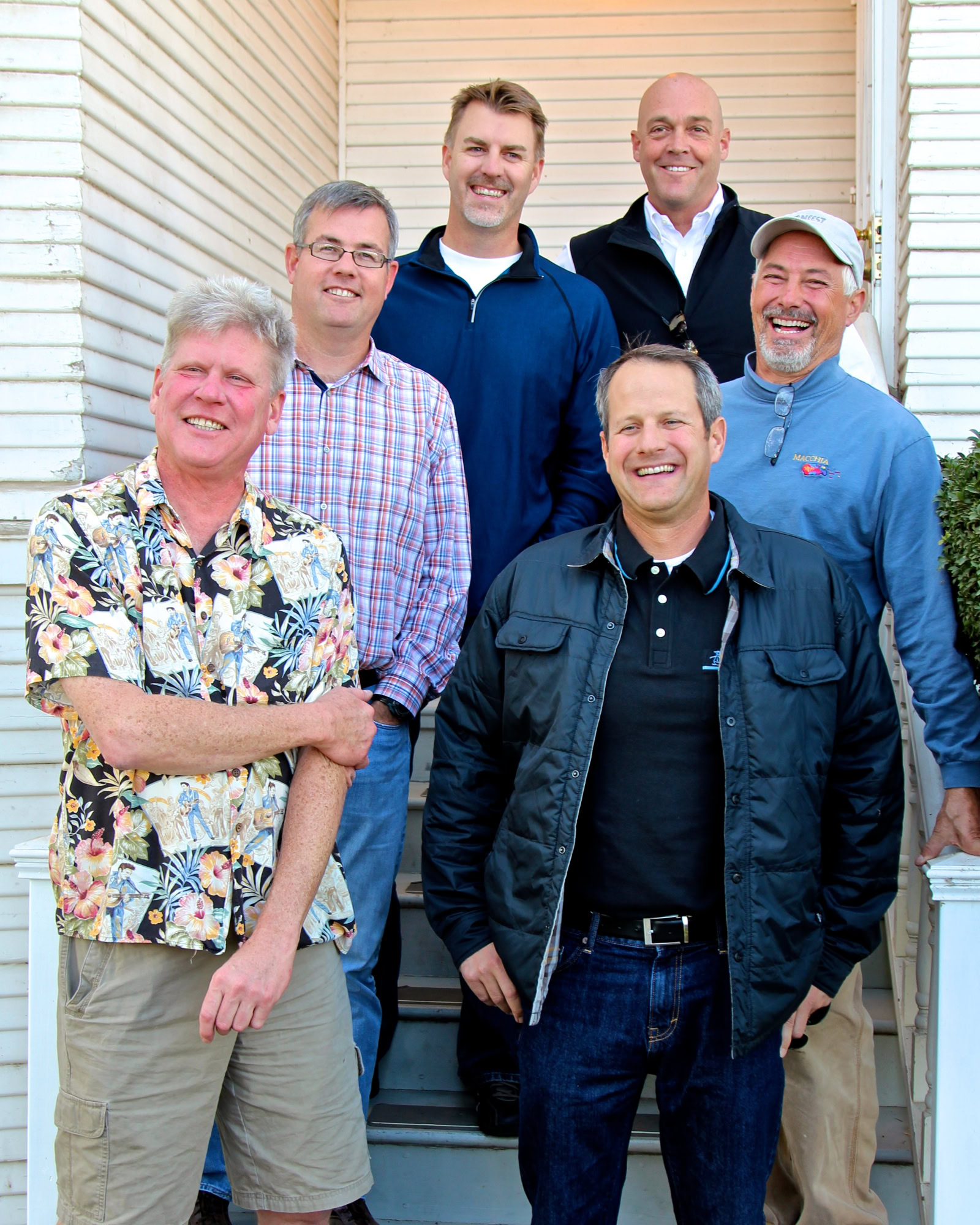 Group of six men smiling outdoors at Lodi Winegrape Commission event, casual attire, sunny day, friendly atmosphere.