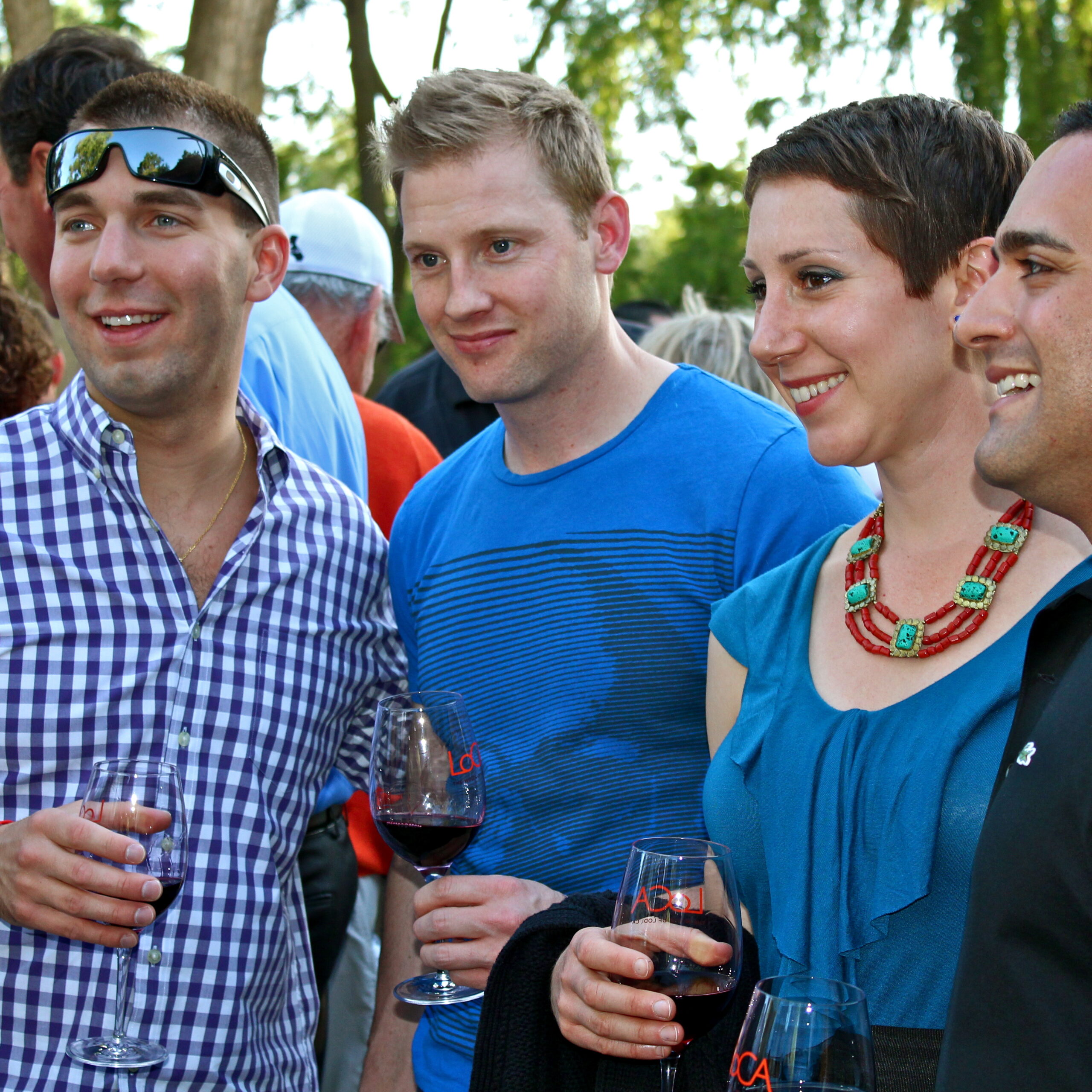 Group of people enjoying wine tasting outdoors at Lodi Winegrape Commission event.