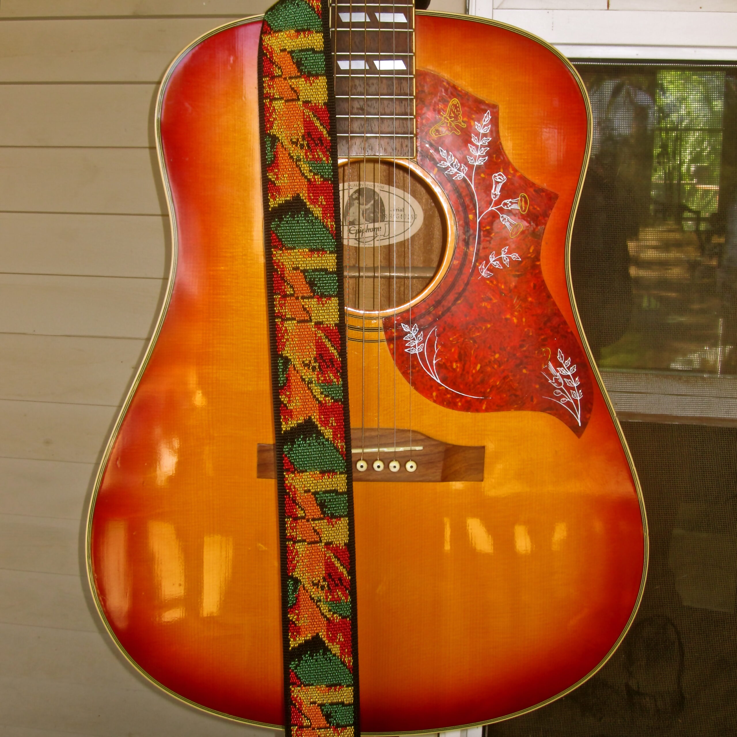 Acoustic guitar with a colorful Lodi wine grape-themed strap, showcasing craftsmanship and musical artistry.