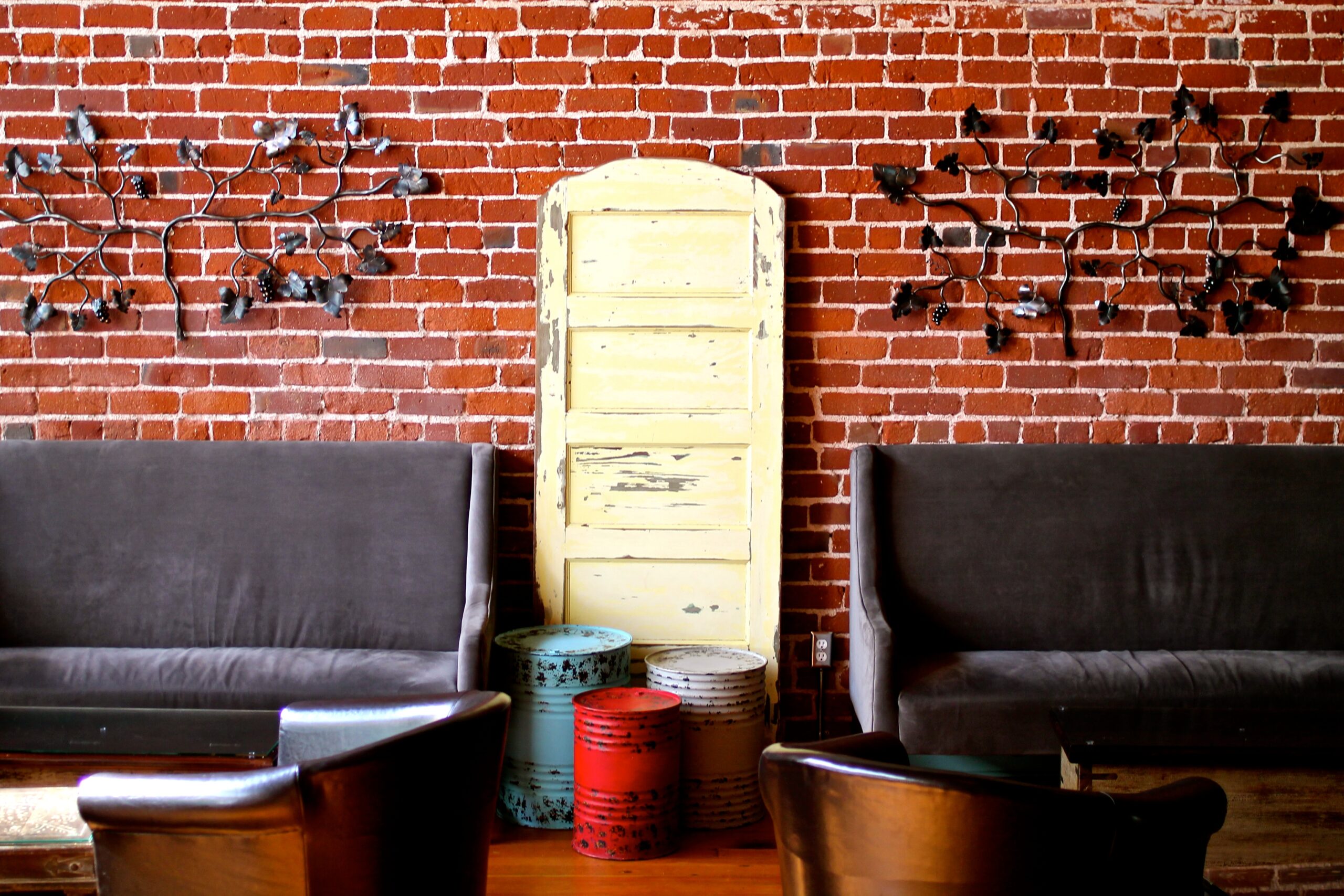 Interior of a wine tasting room with brick walls, vintage decor, and seating area for visitors.