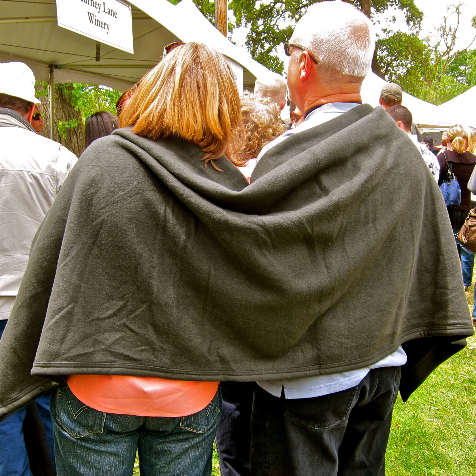 People at a wine event in Lodi, California, with a woman and man sharing a blanket outdoors.