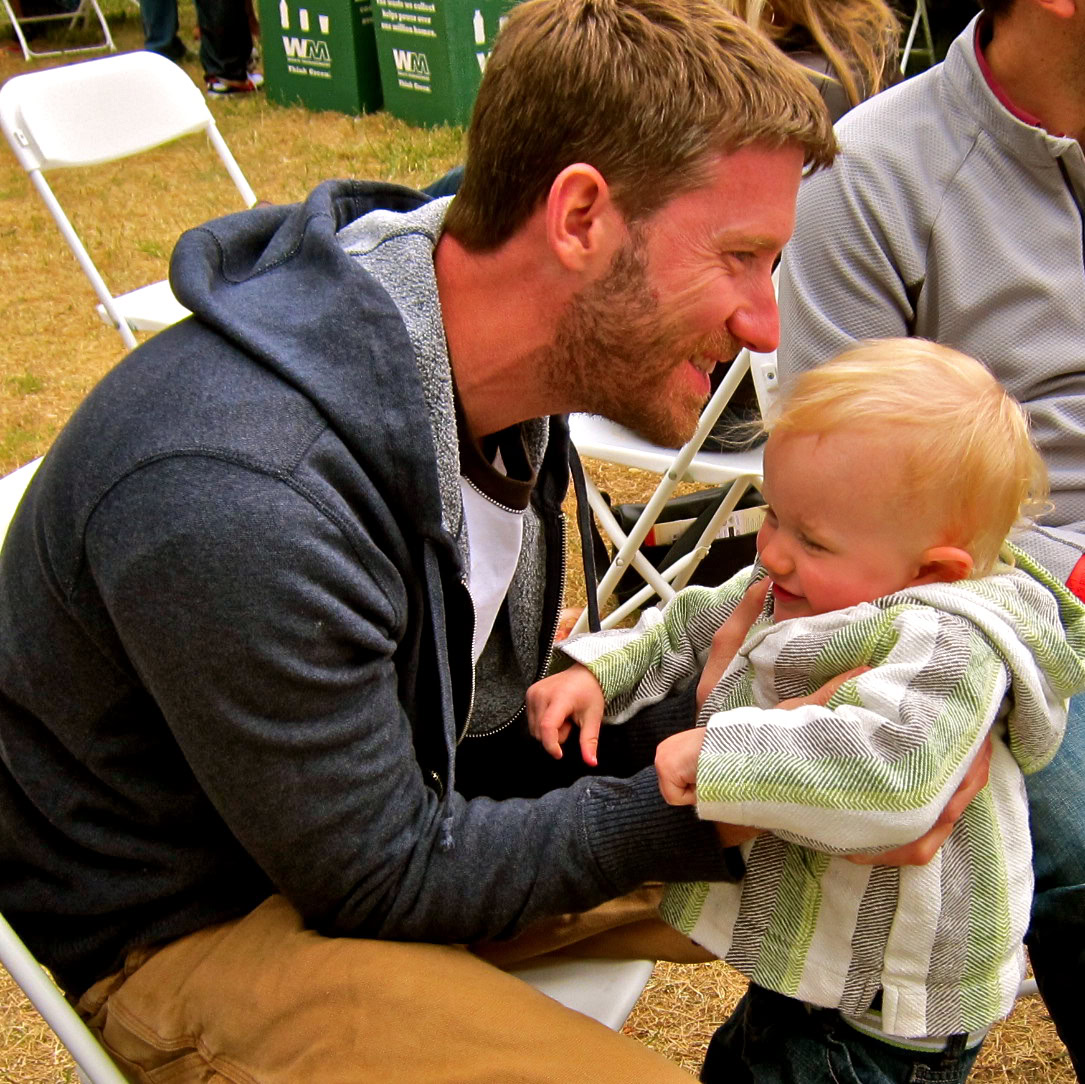 Man and child enjoying a moment at a Lodi wine event, showcasing family-friendly wine community activities.