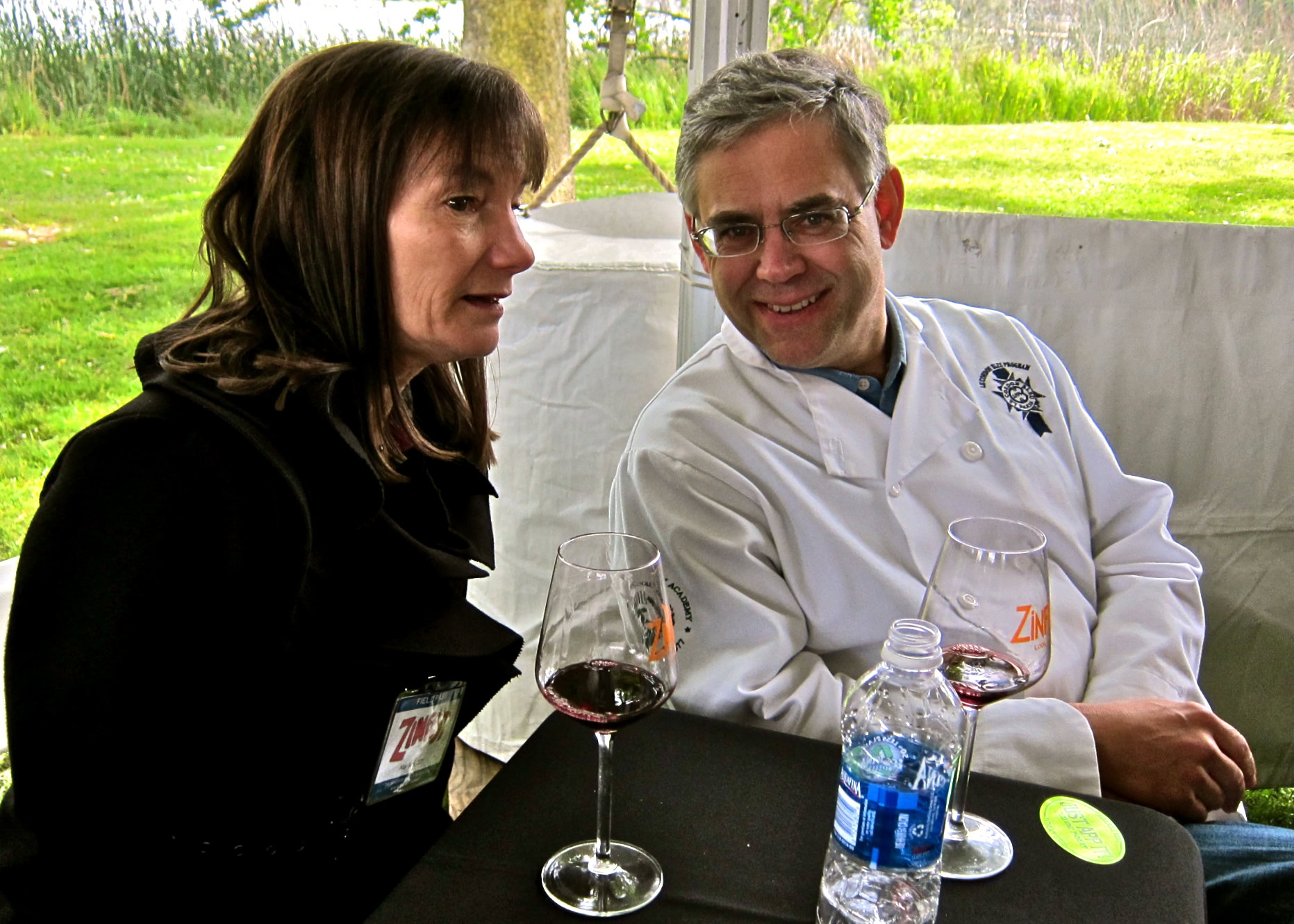 Two people enjoying wine tasting at a Lodi Winegrape Commission event outdoors.