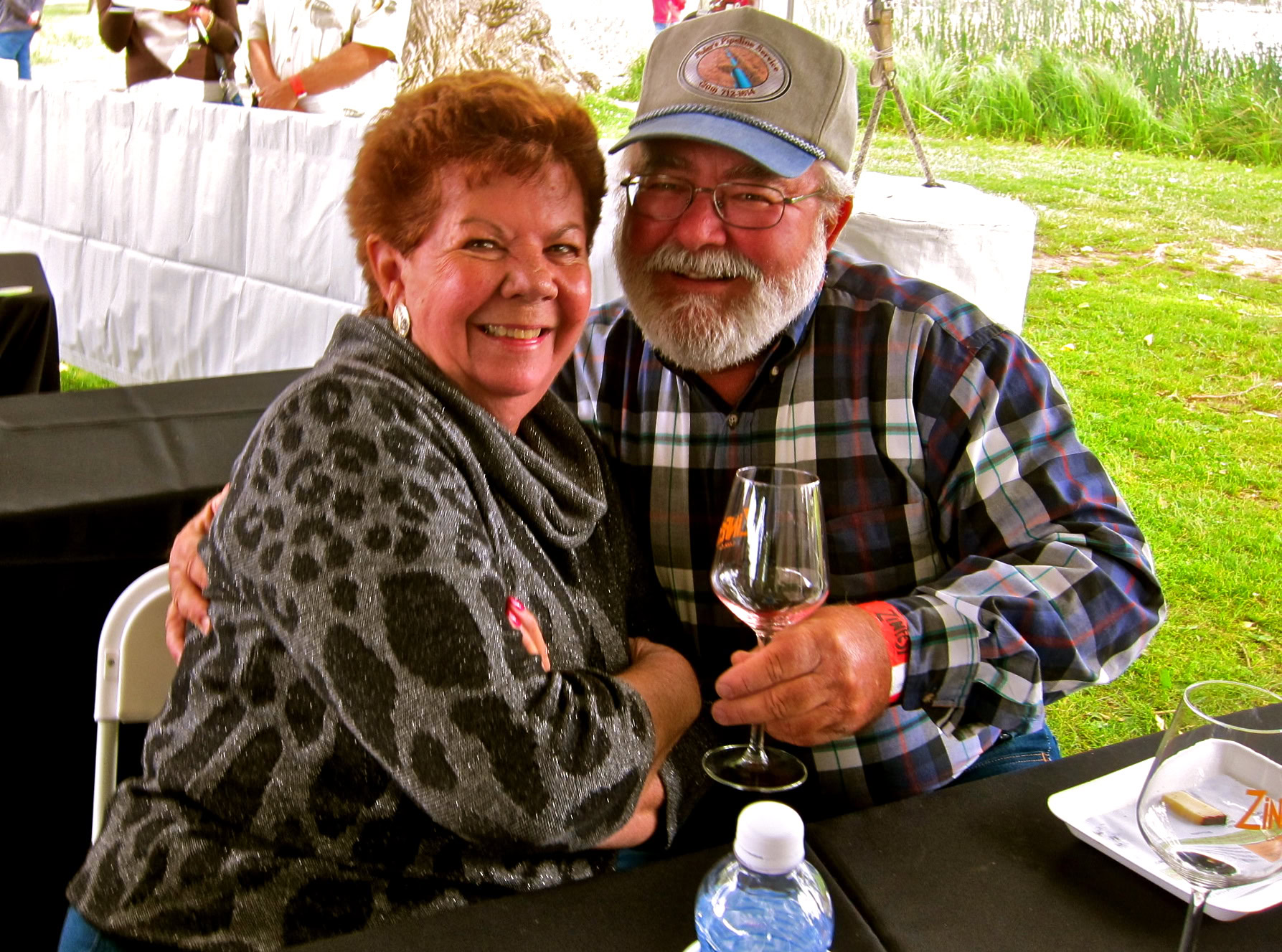 Smiling couple enjoying wine tasting at Lodi Winegrape Commission event outdoors.