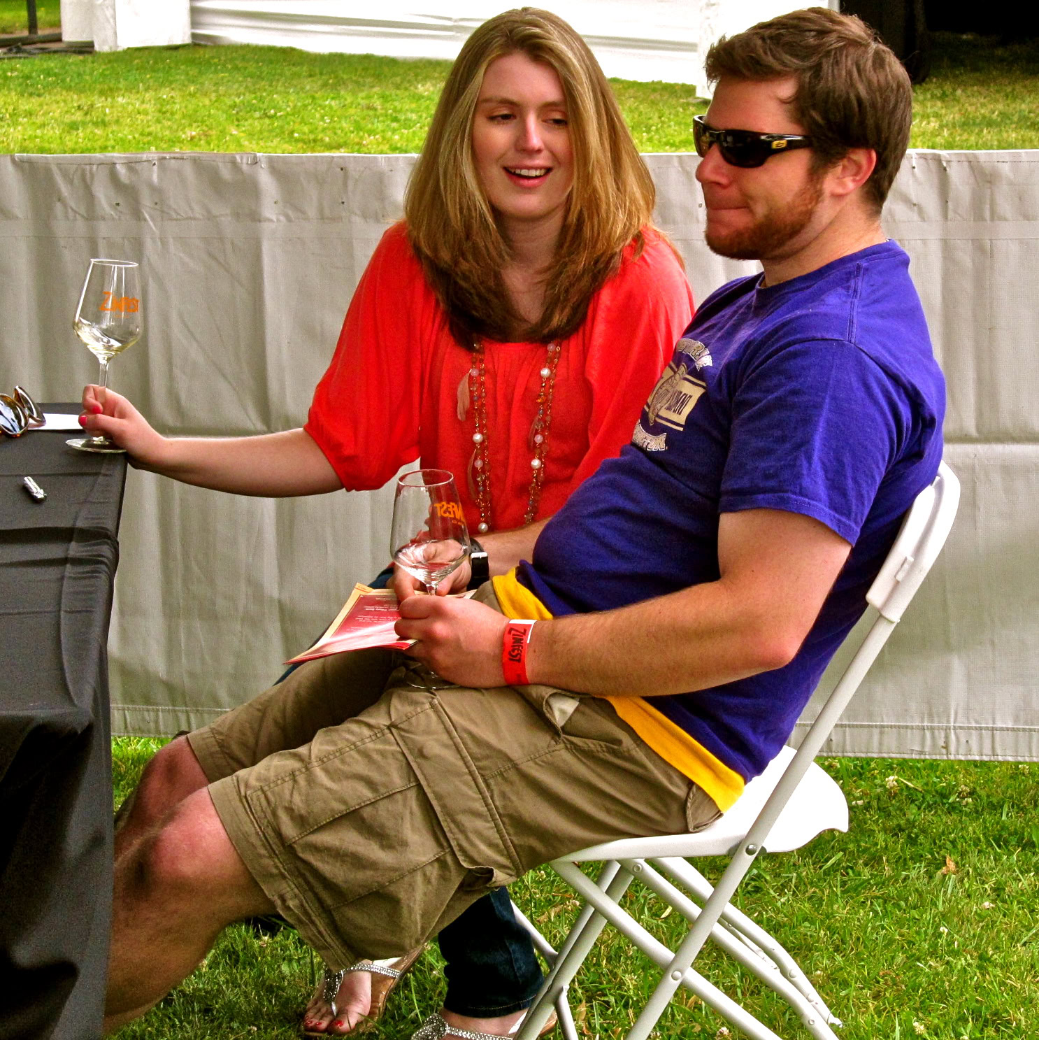 Two people enjoying wine at a Lodi Winegrape Commission event outdoors.