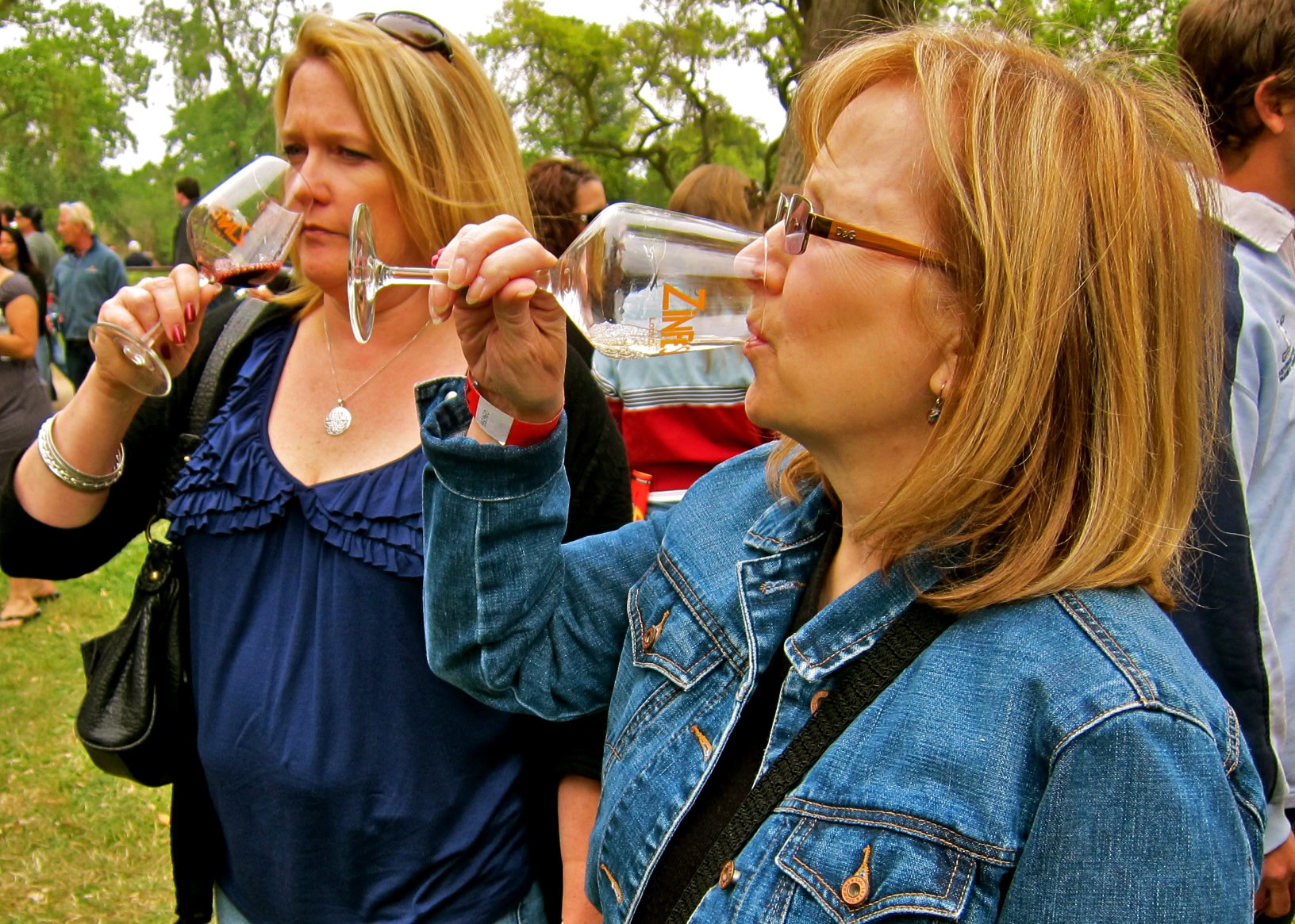 Women enjoying wine tasting outdoors at a Lodi Winegrape Commission event.