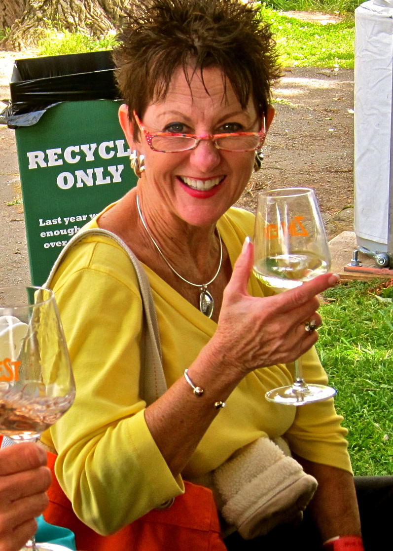 Woman enjoying a glass of wine at a Lodi Winegrape Commission event outdoors.
